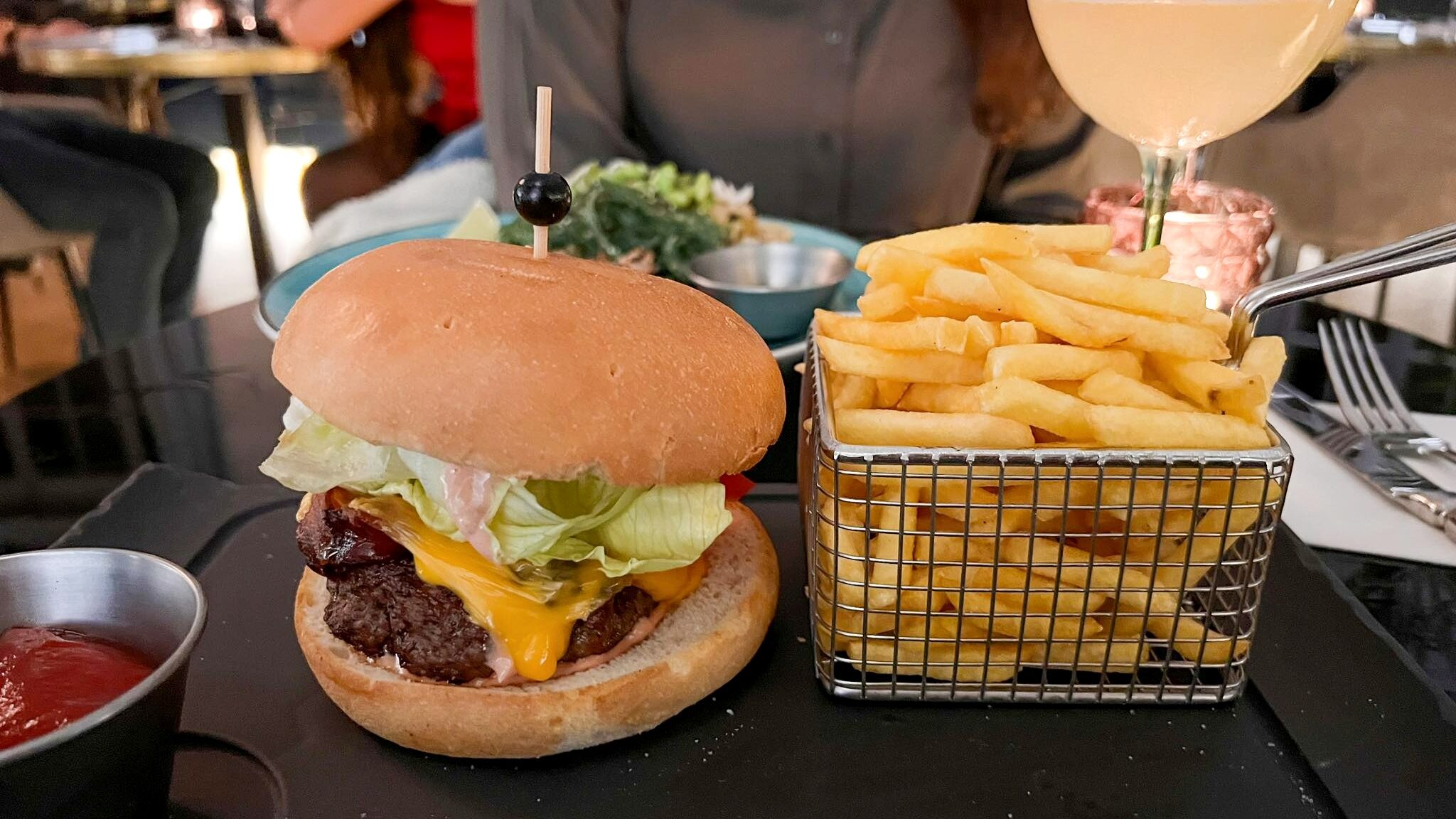 Burger and fries served on black slate.