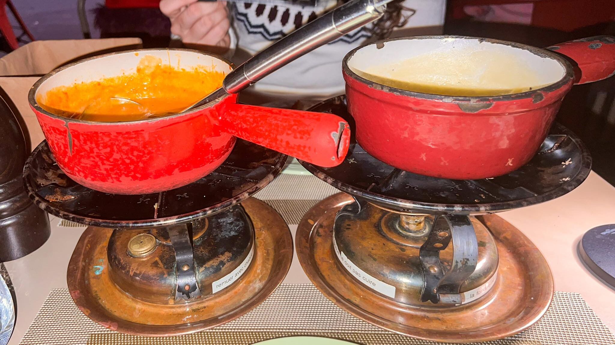 Two red pots with fondue inside.