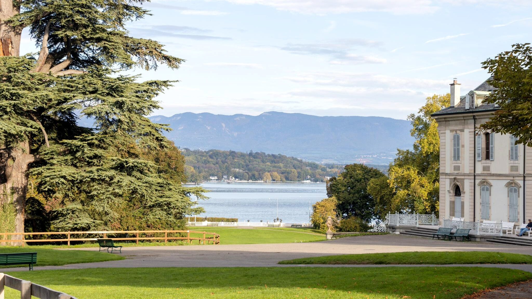 Park space with house next to lake.