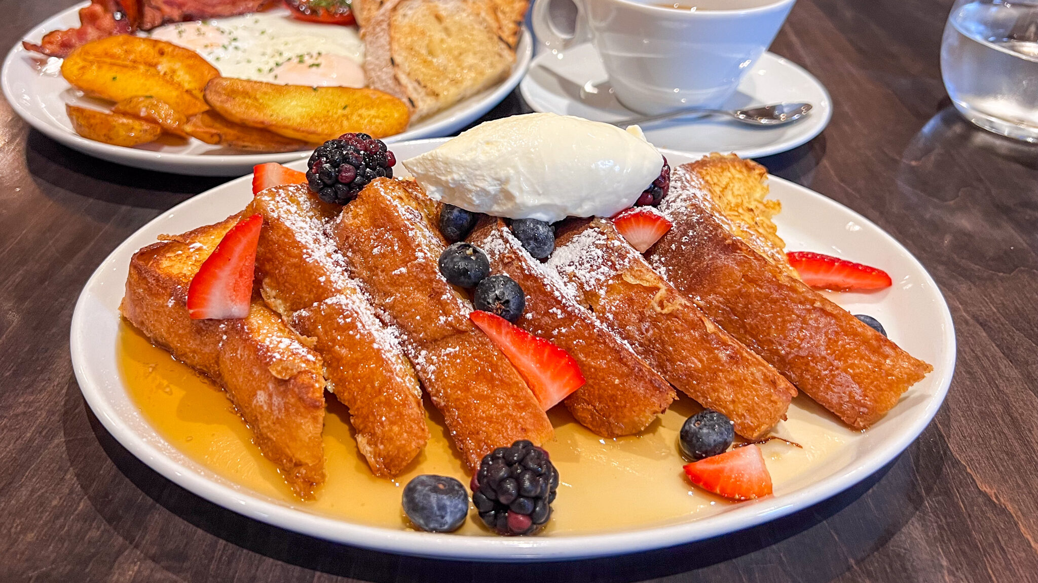 Plate of French toast with syrup and fruit.