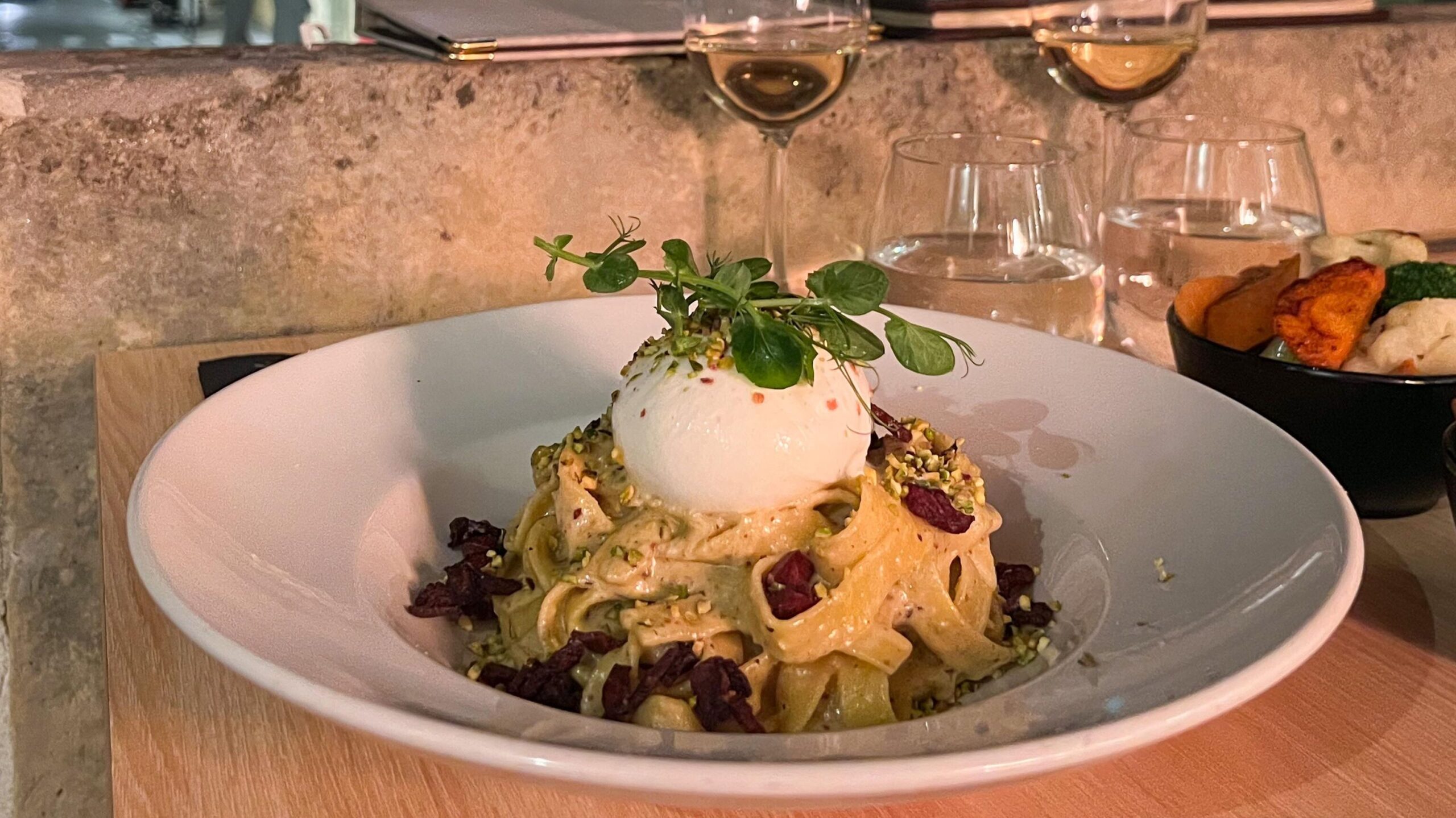 Dish of pasta with burrata ball on top.