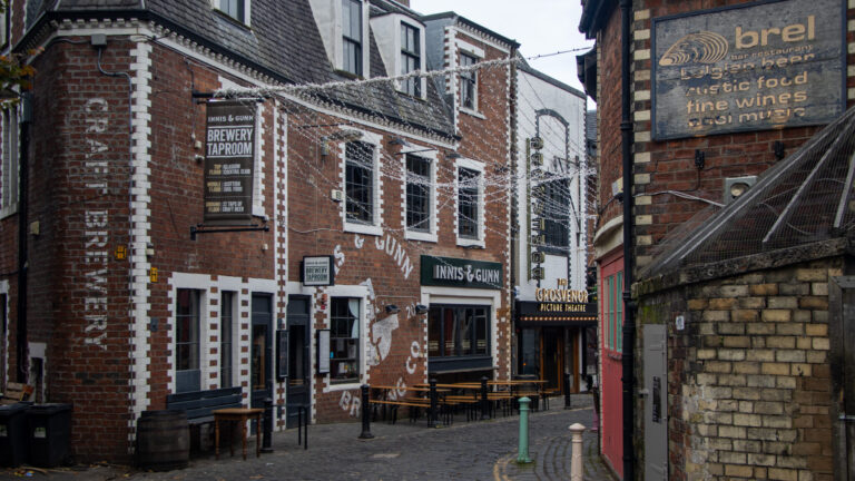 Historic lane in Glasgow with restaurants and bars.