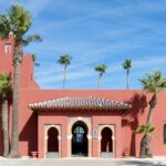 Red painted modern castle along waterfront.