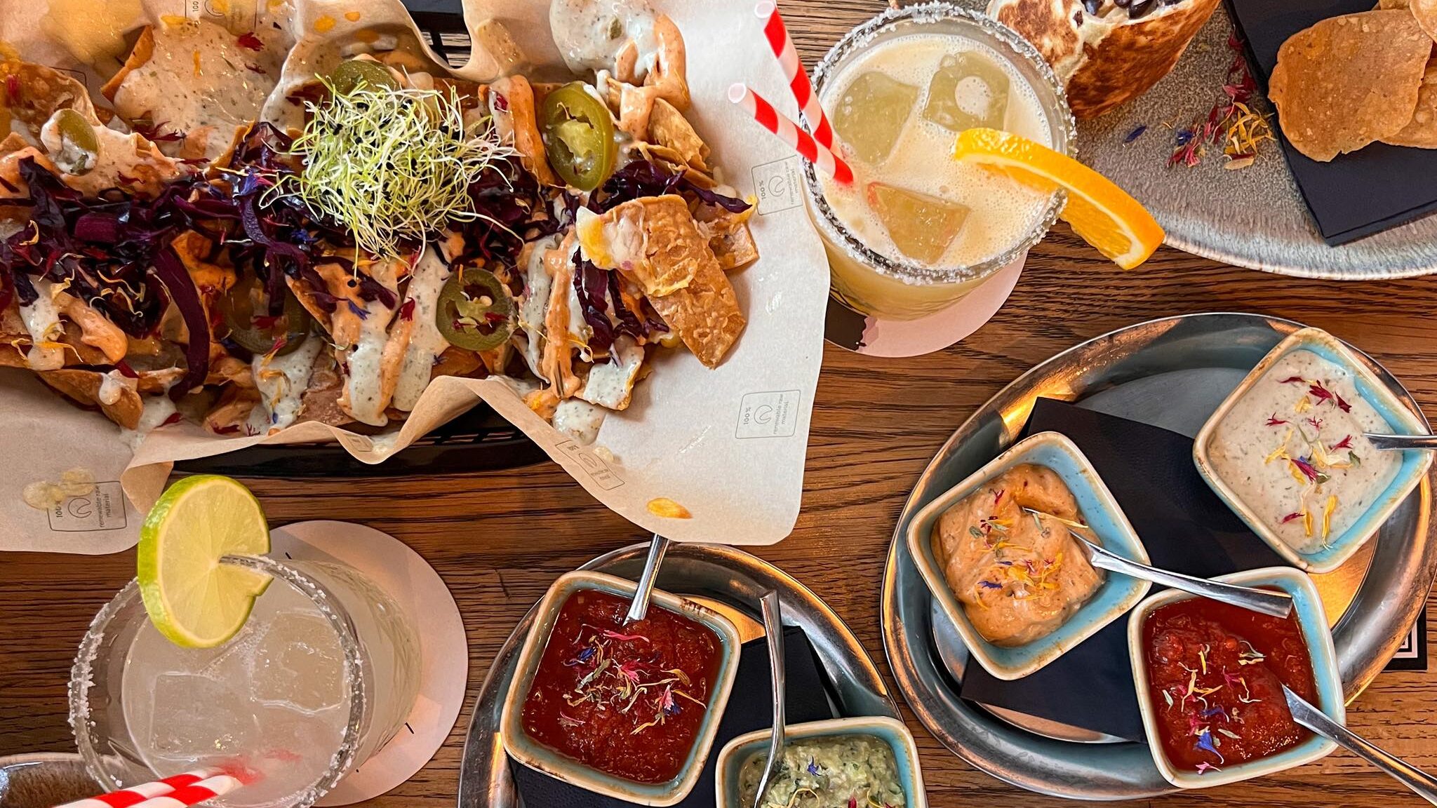 Selection of Mexican food on table with cocktails.