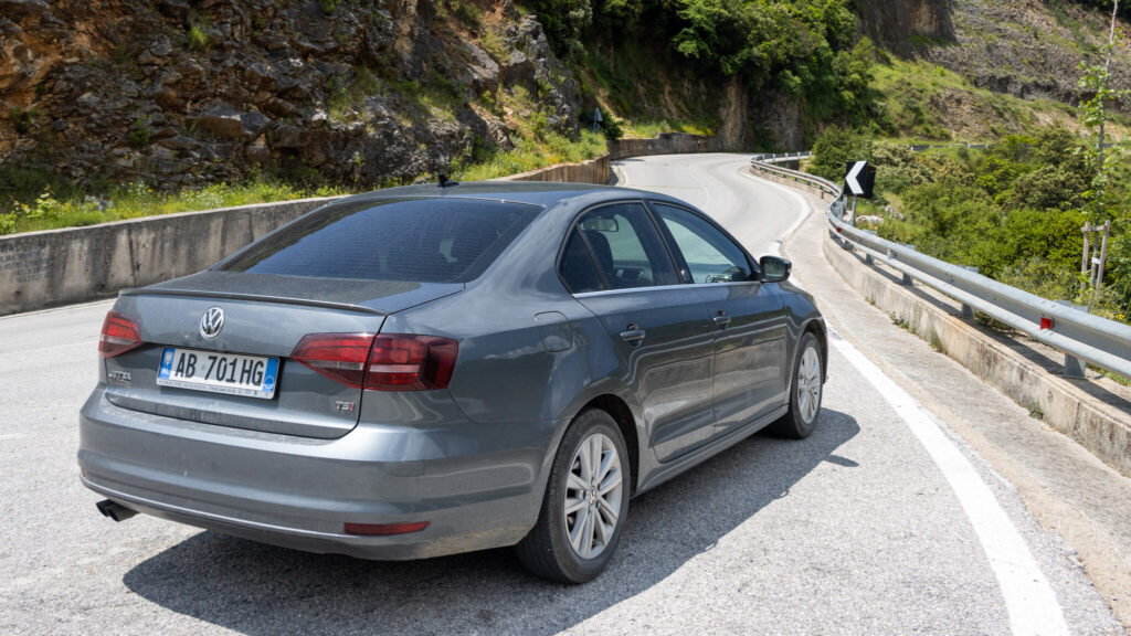 Grey car parked at viewpoint Albania road trip.