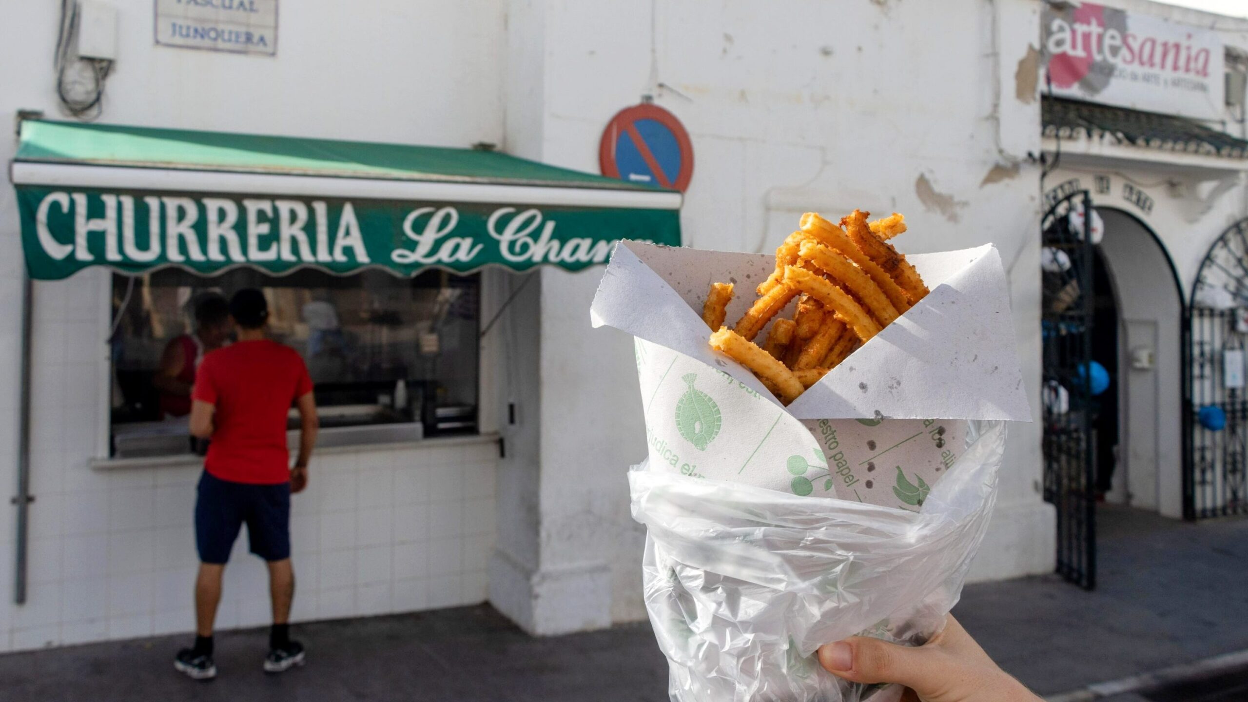 Thin churros in front of churro shop.