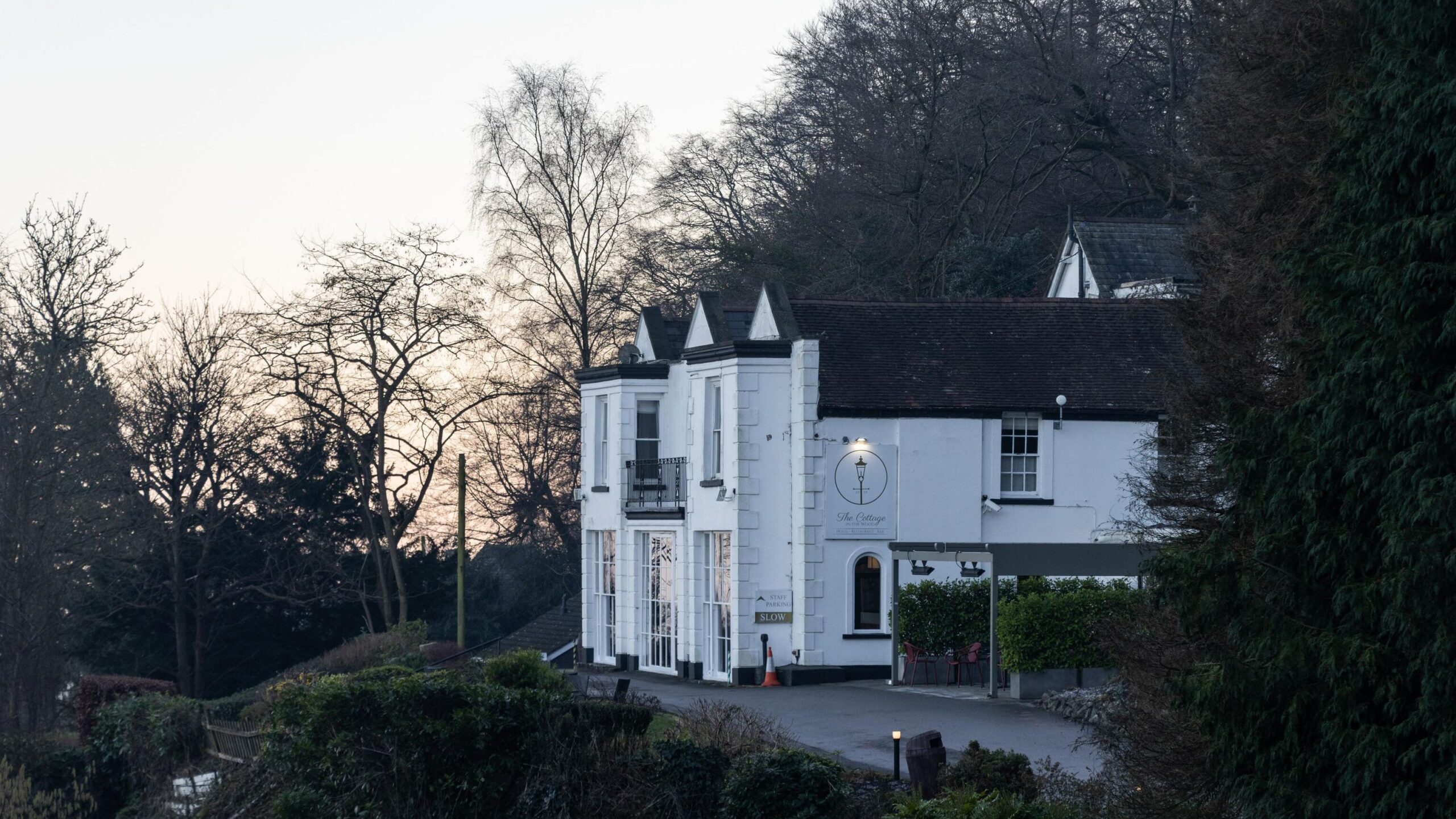 White painted hotel in countryside on hill.