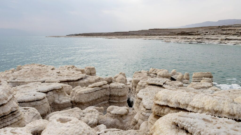 View of the Dead Sea with salt rock formations.