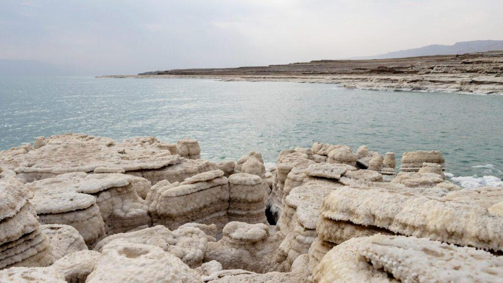 View of the Dead Sea with salt rock formations.
