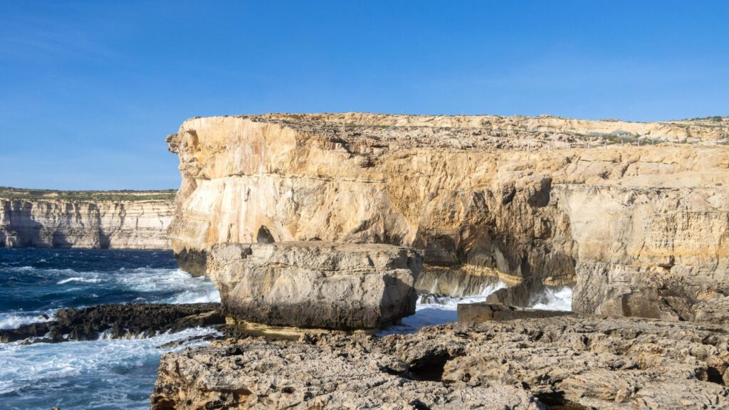 Large rock separated from coastline.