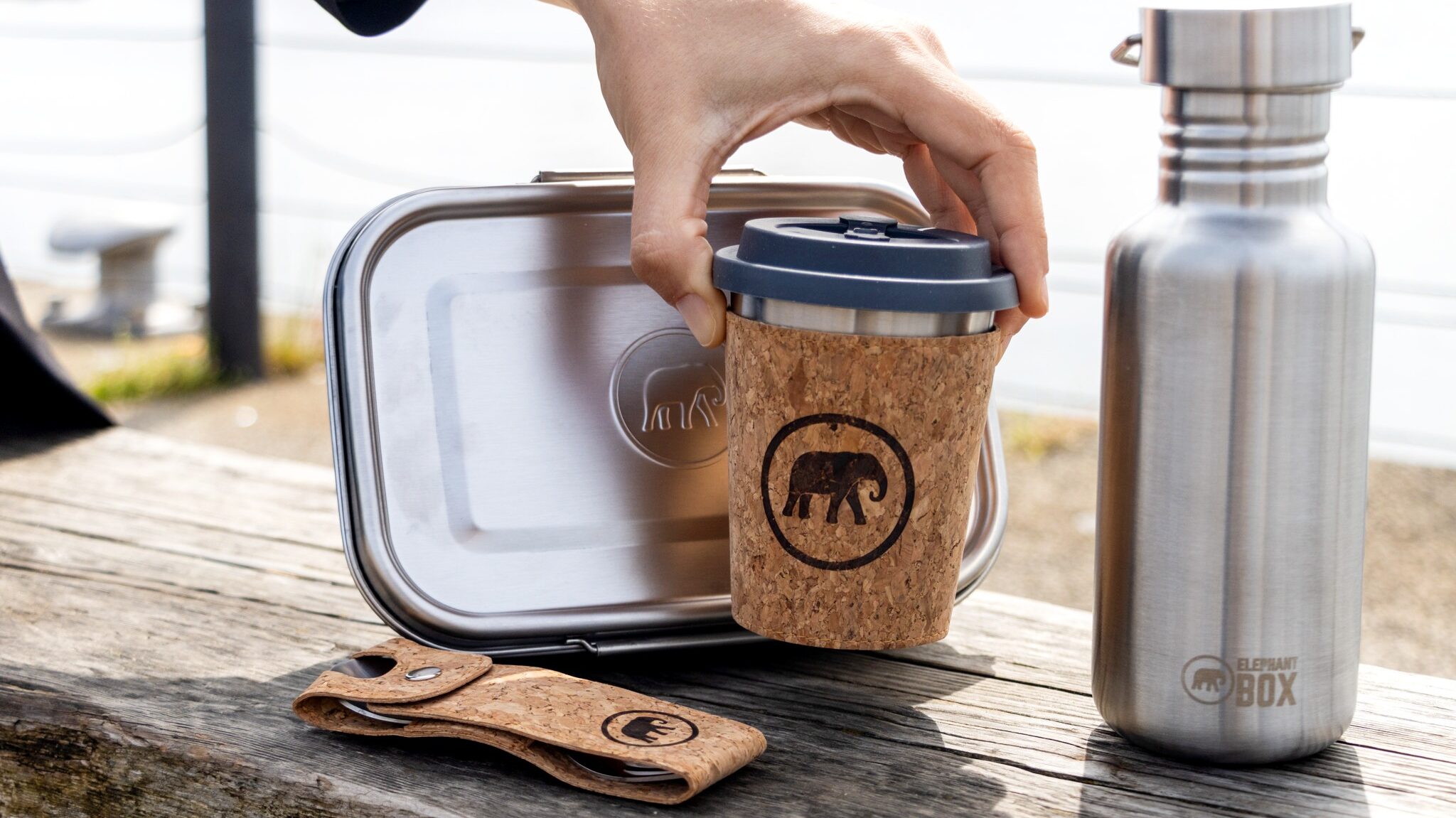 Reusable steel bottle and lunch box with coffee cup.