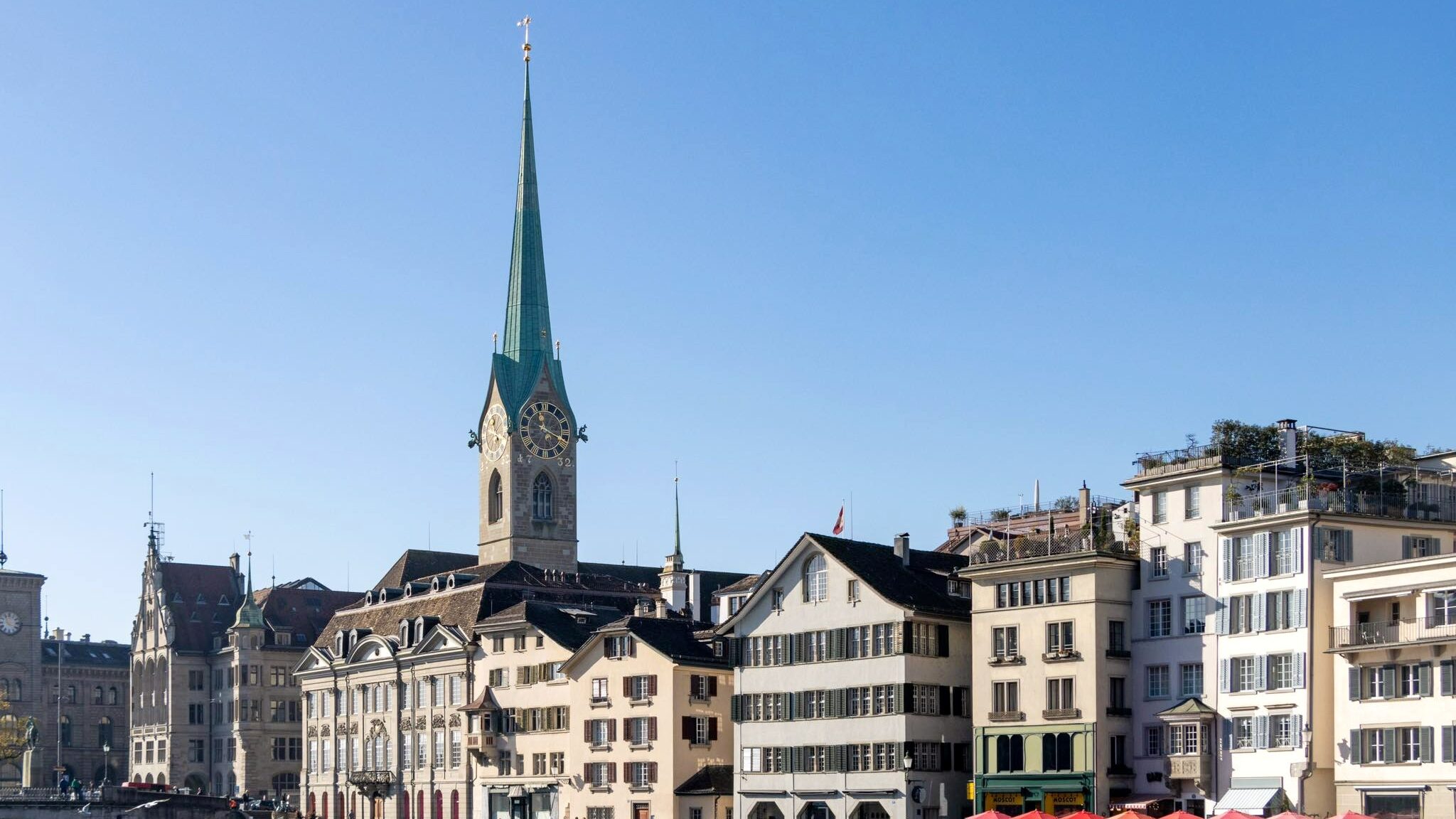 Church spire reaching out over rooftops in Zurich.