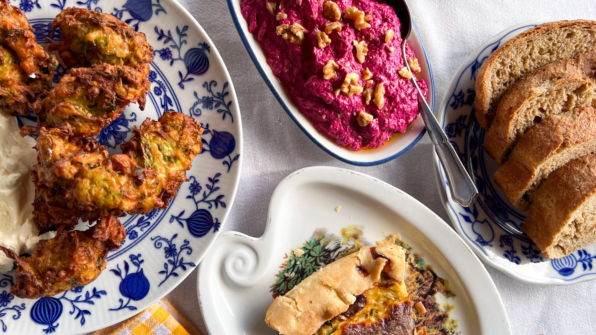 Vegetarian seasonal dishes on white table cloth.