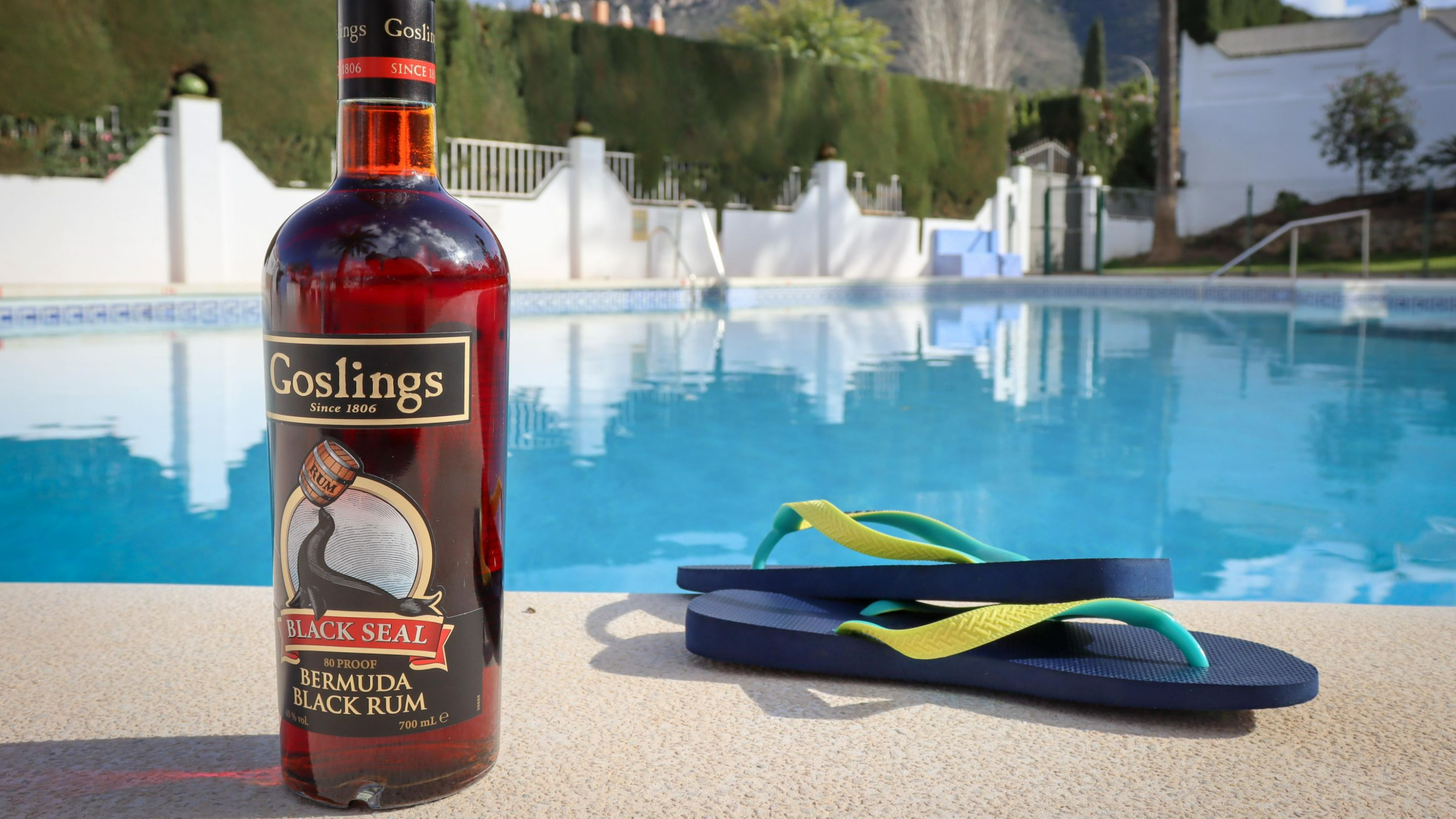 Bottle of Goslings rum next to pool.