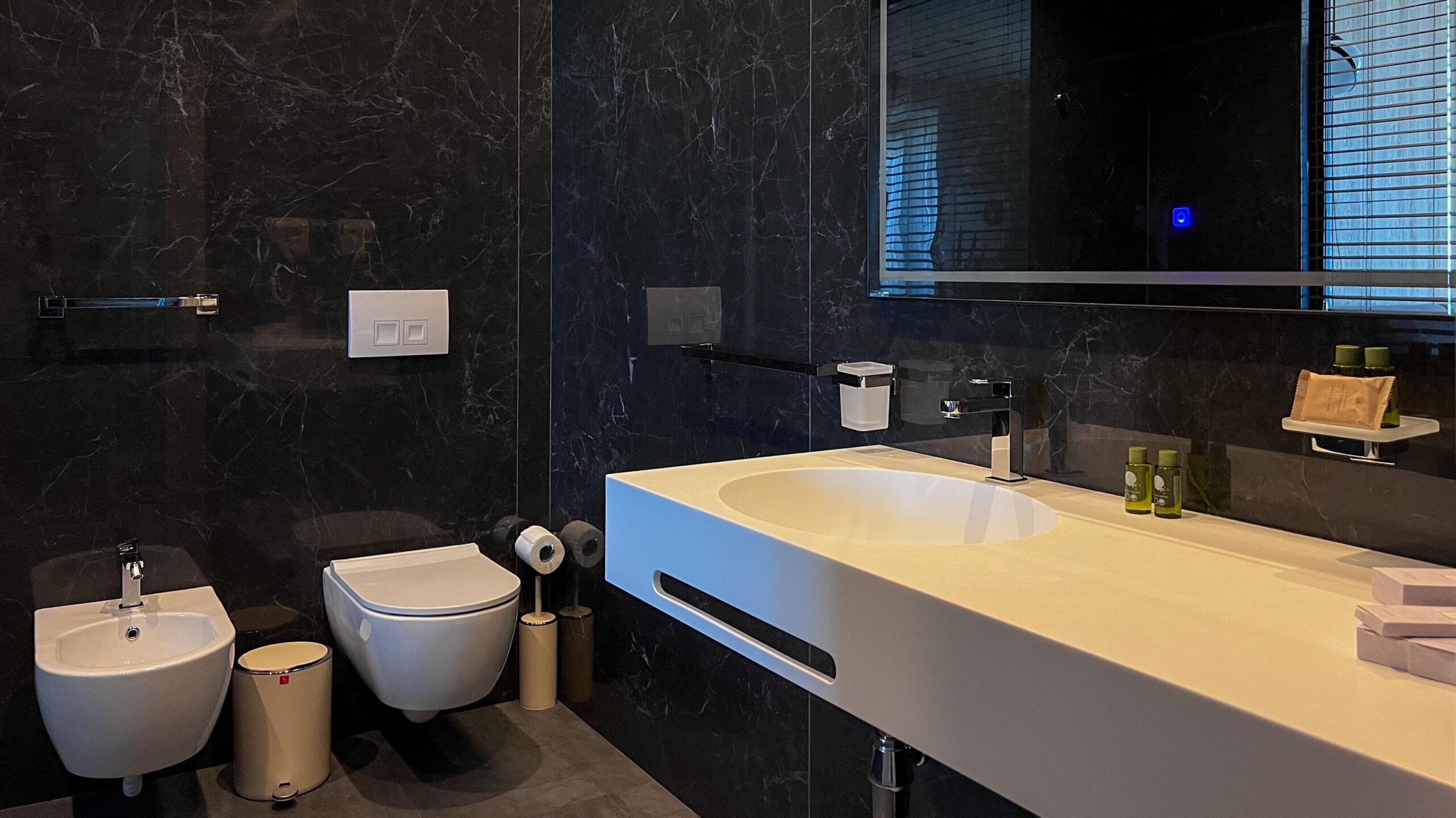 Bathroom with black tiles and white sink.