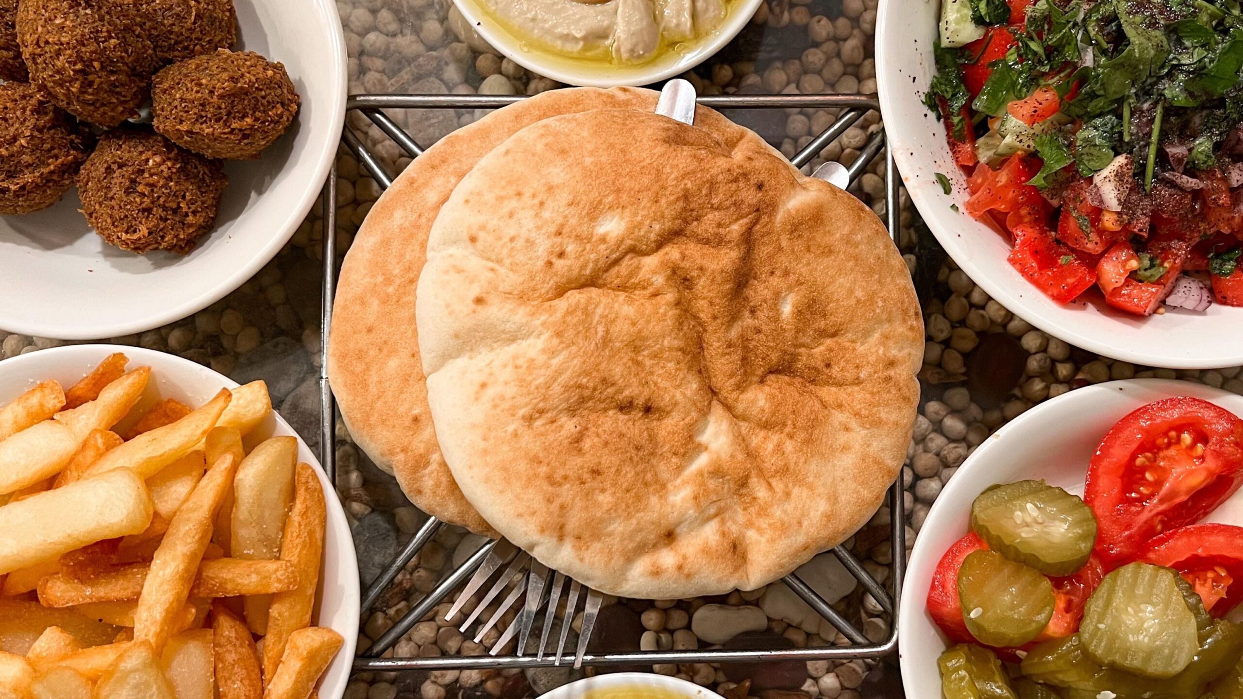 Pita bread and hummus with sides.