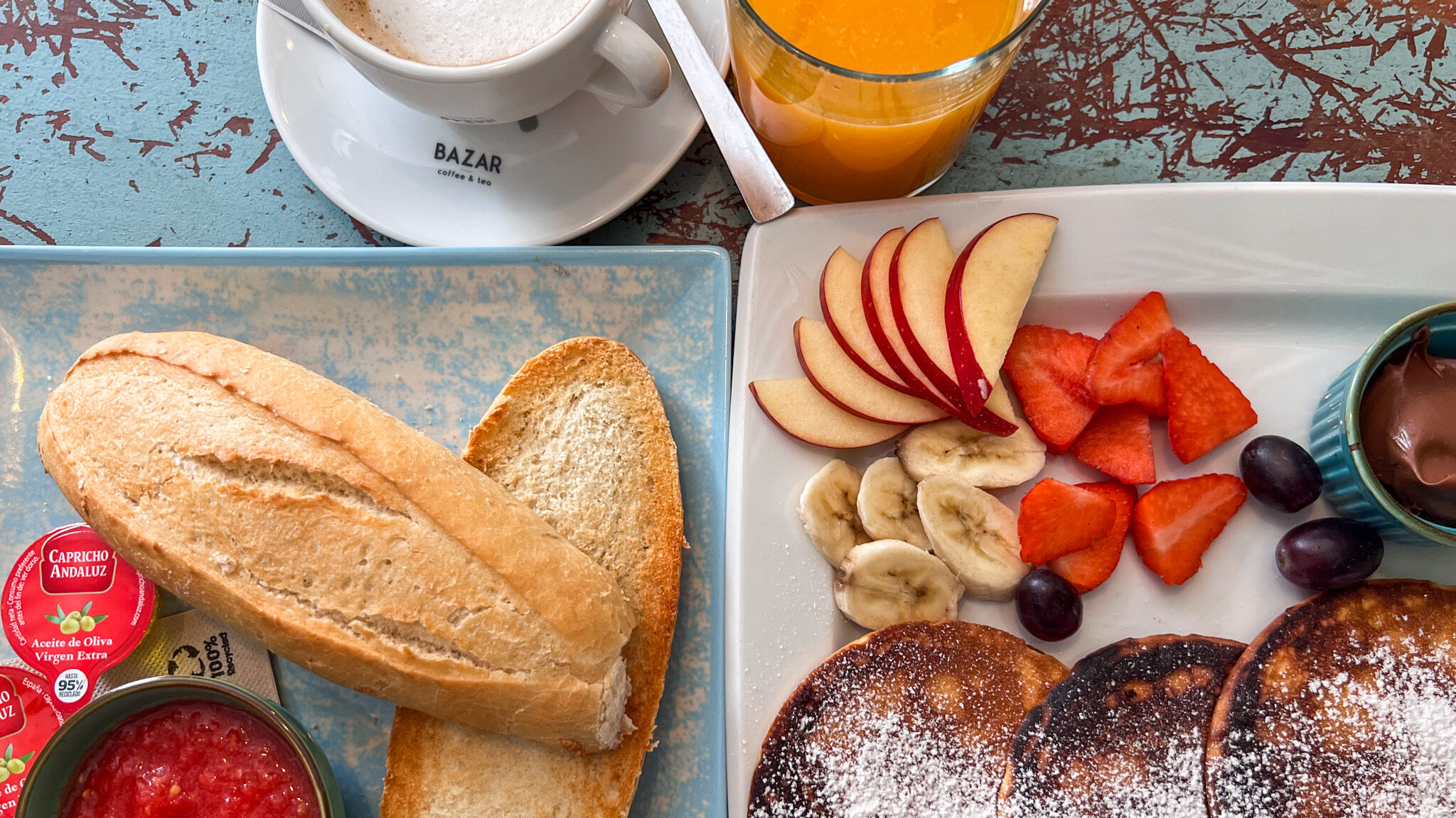 Bread with tomato spread and pancakes with fruit.