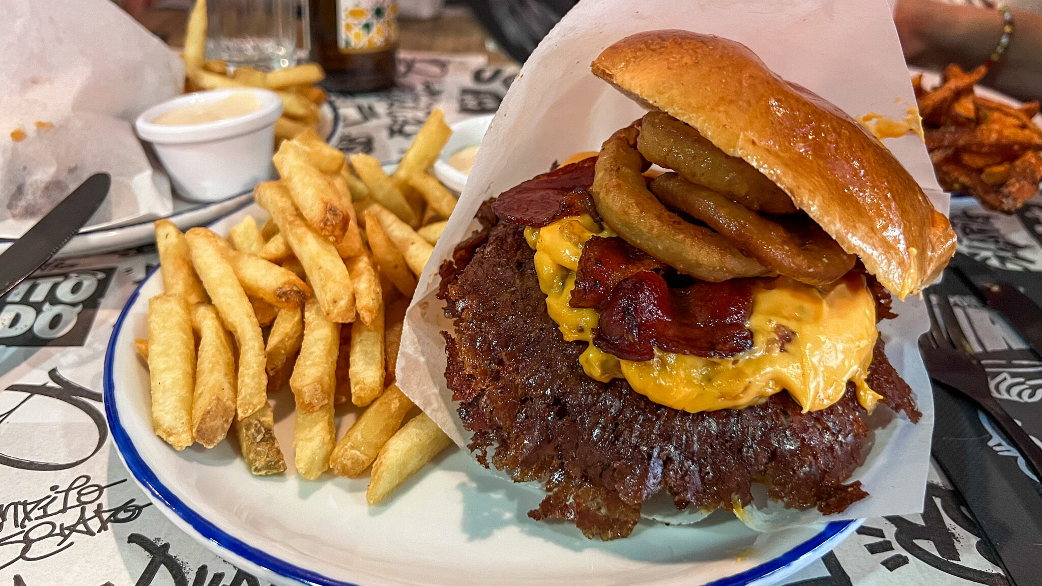 Large smash burger with fries on the side.