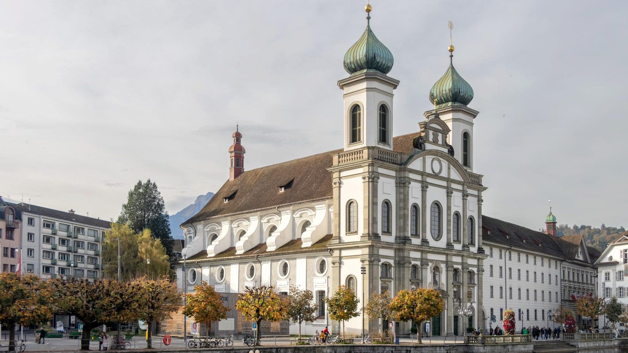 White church sitting next to river.