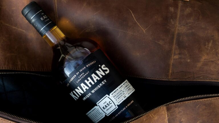 Bottle of whisky sitting inside leather bag.