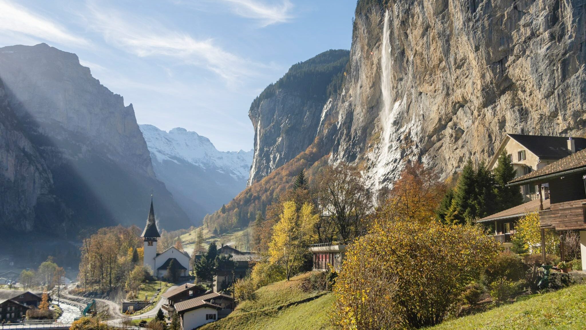 View of village in valley with waterfall.