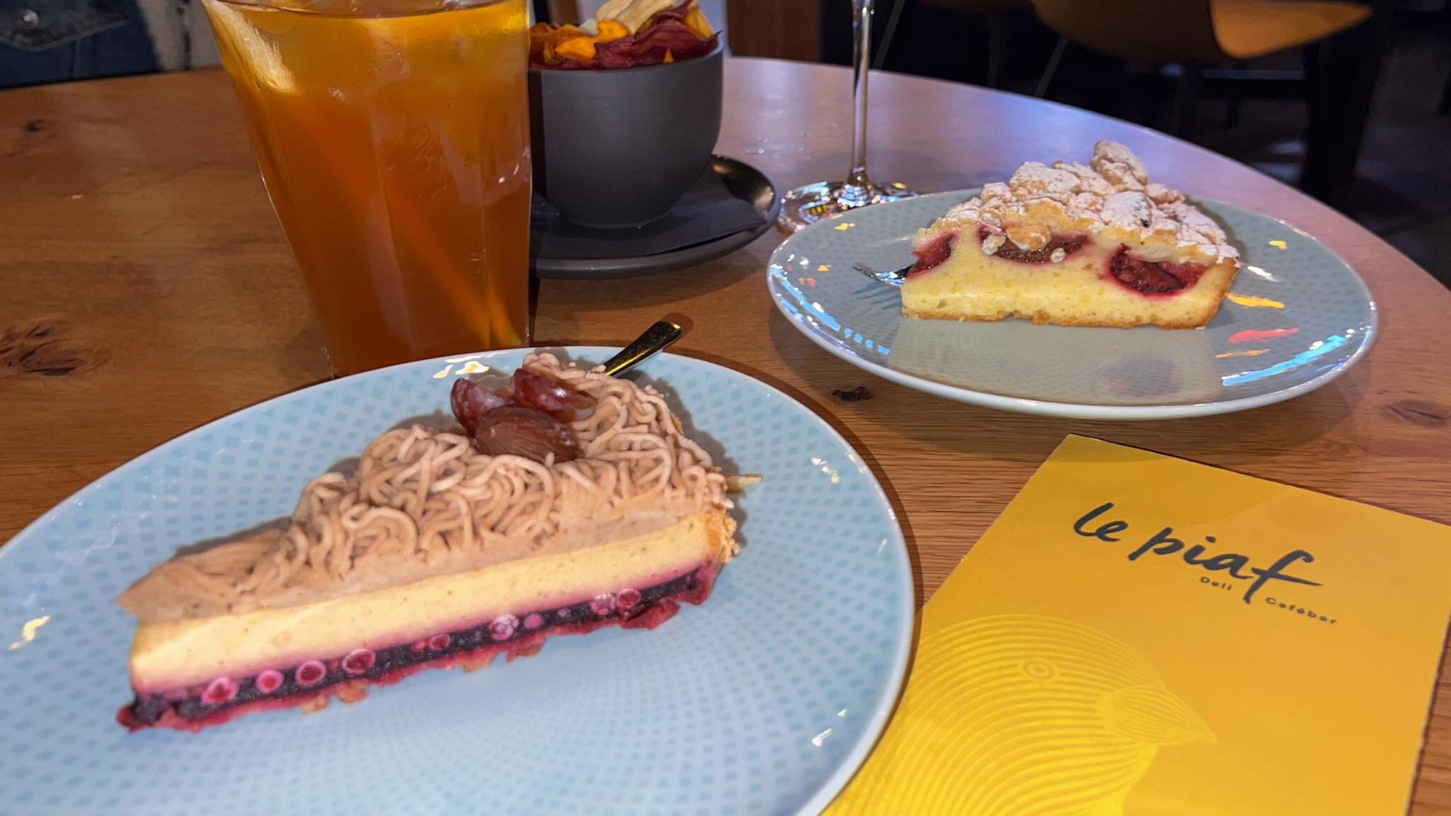 Two cakes and drinks in cafe.