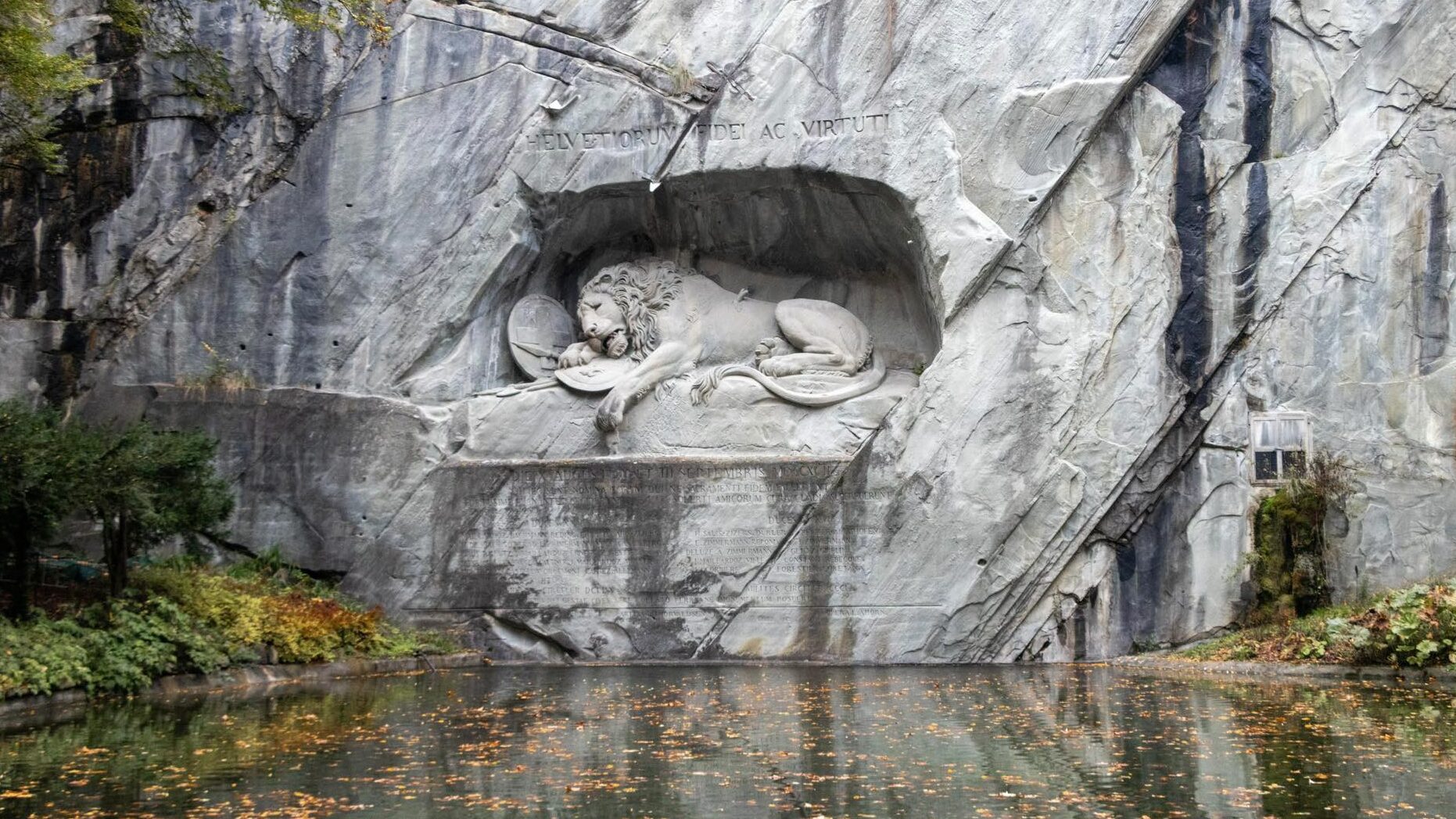 Lion statue carved into stone wall.