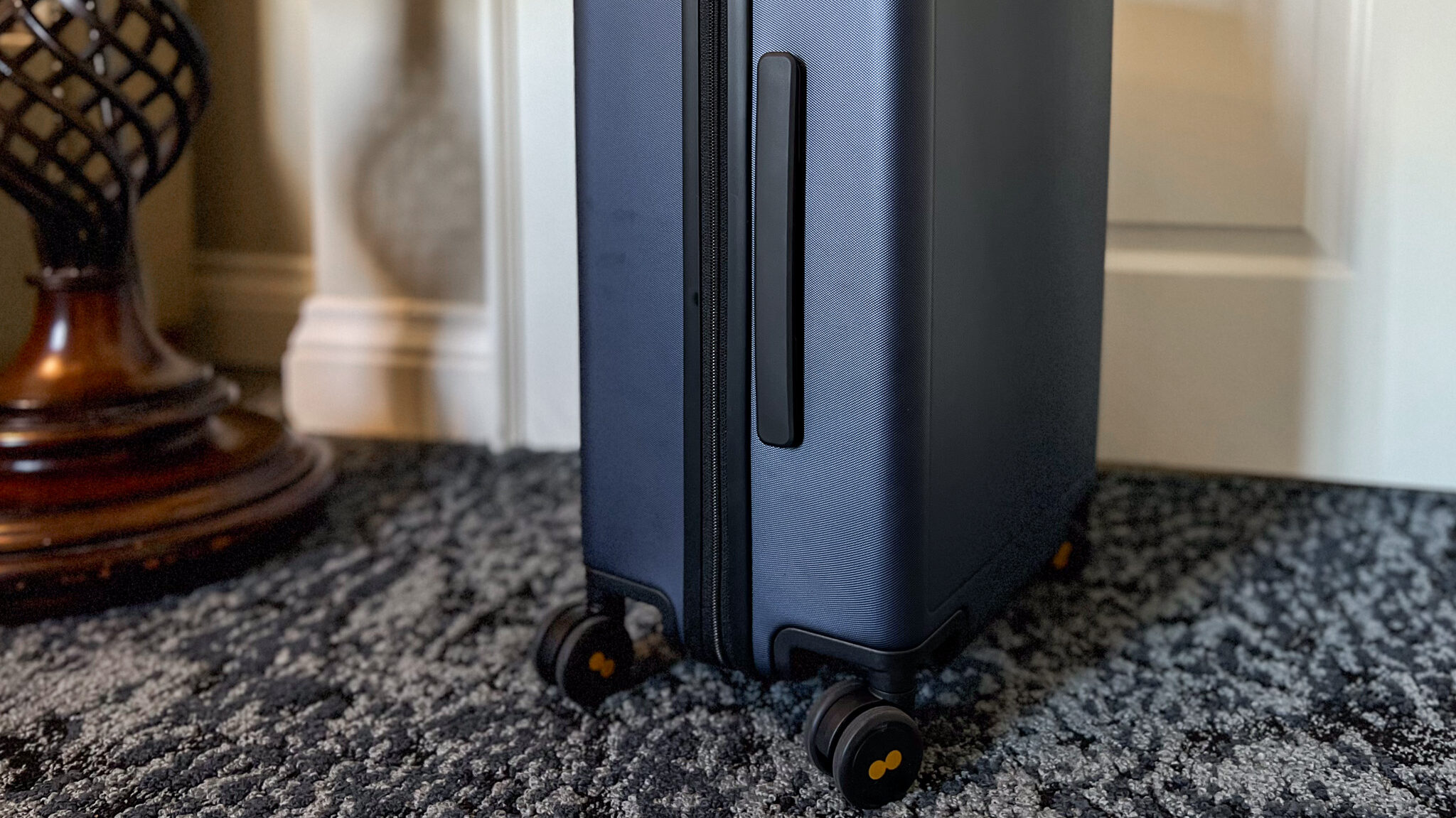 Side of blue suitcase with handle.