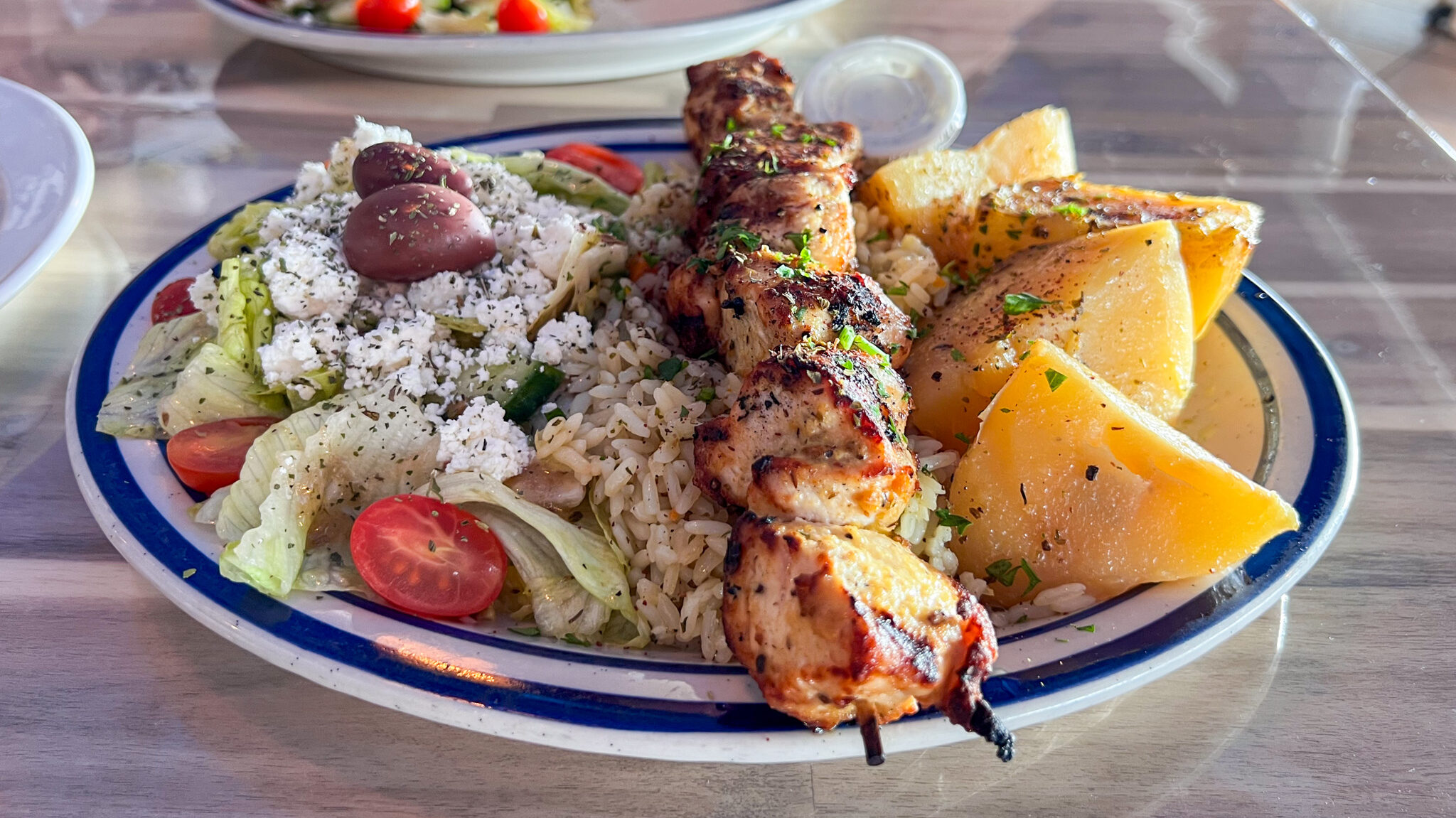 Chicken skewer served with salad and potatoes. 