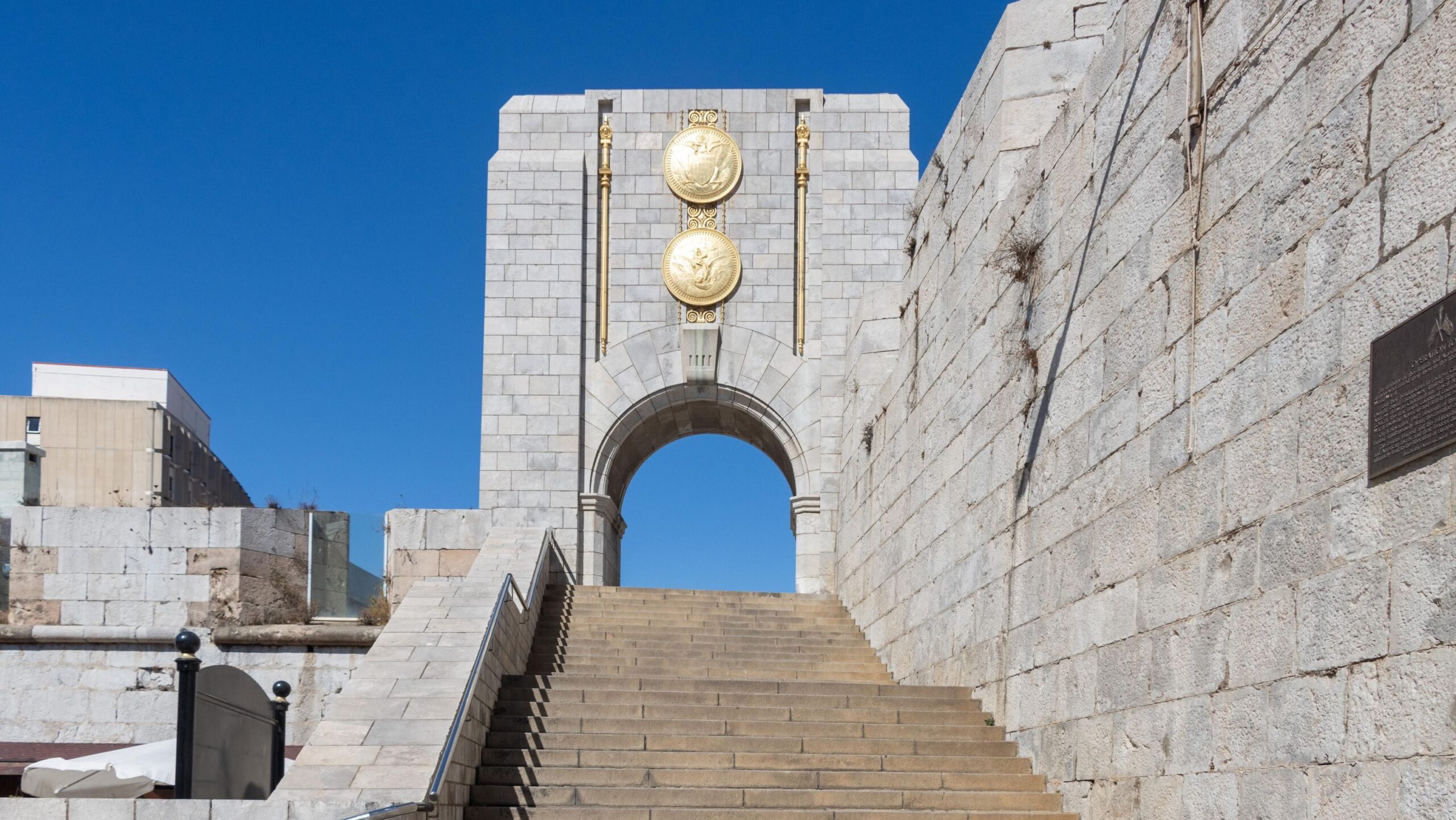 Arched war memorial at the top of steps.