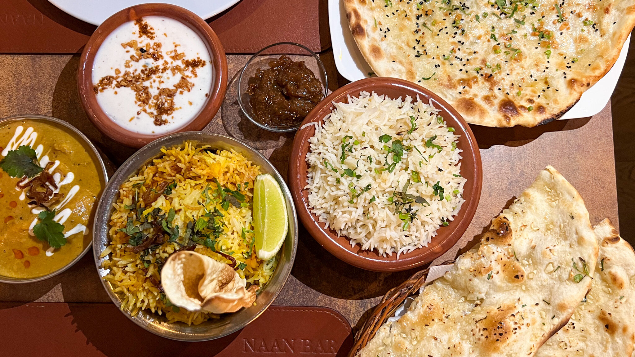 Selection of curries and naan bread in restaurant.