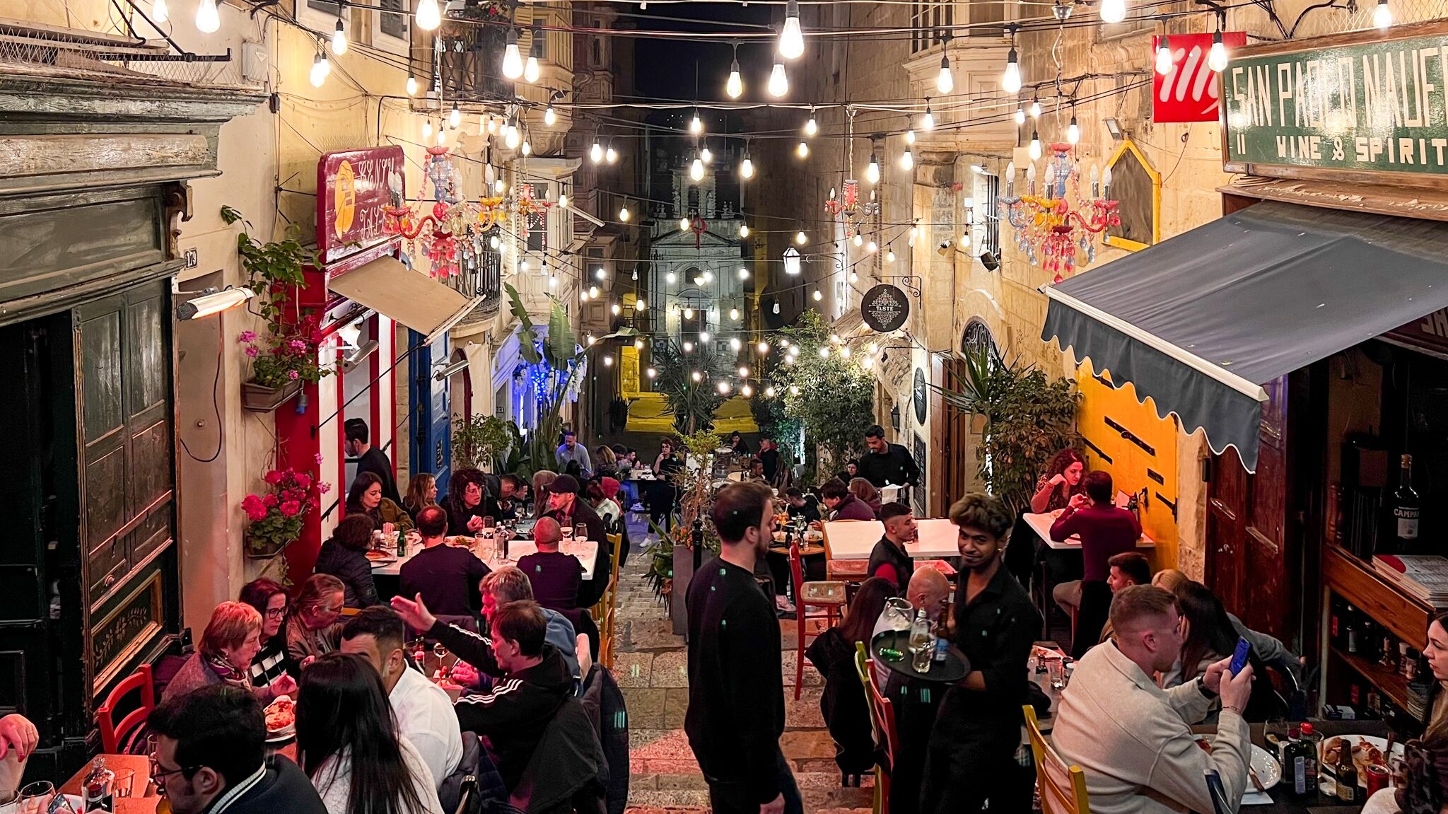 Vibrant street with bars at night.