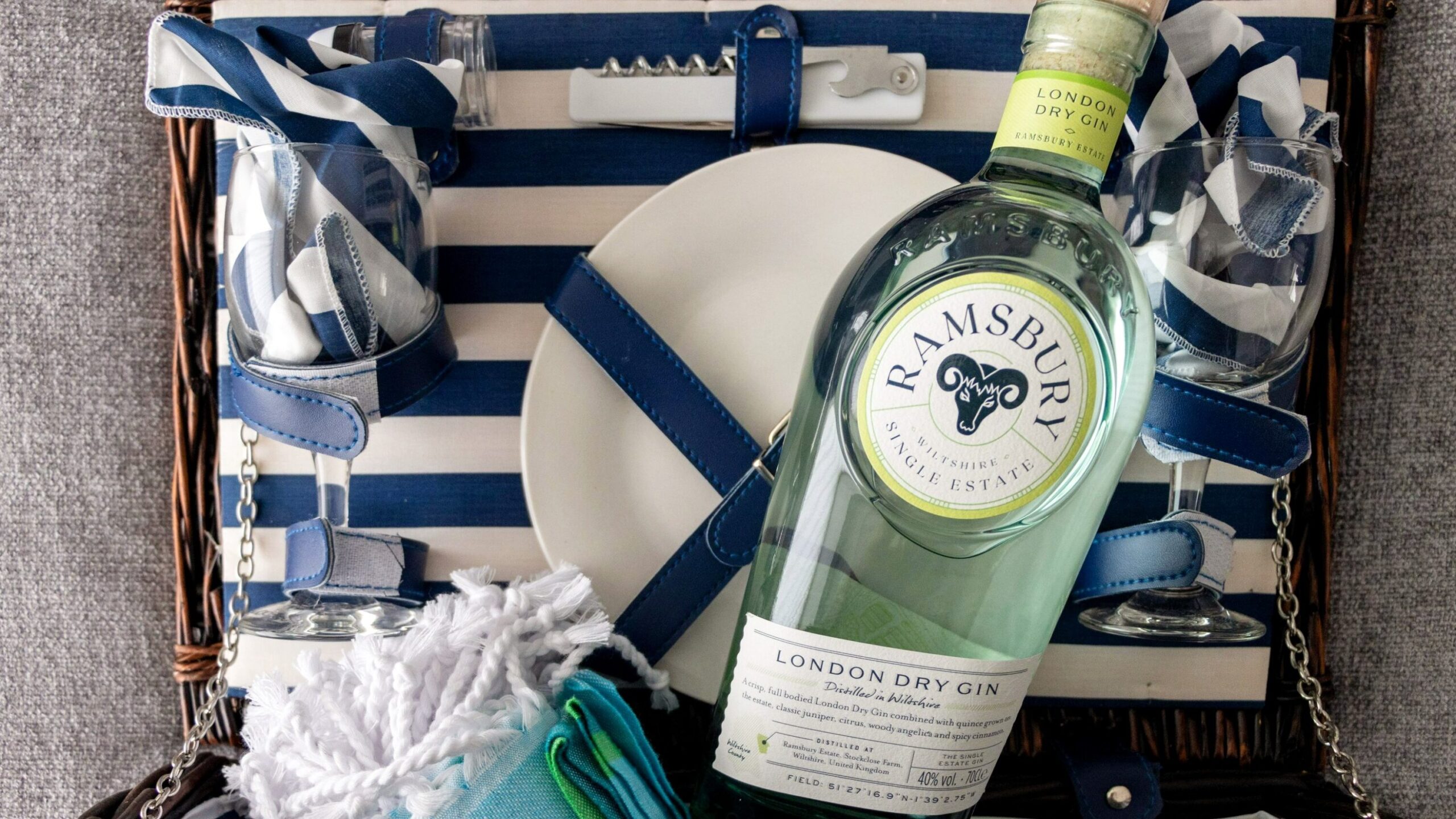 Bottle of gin sitting inside picnic basket.