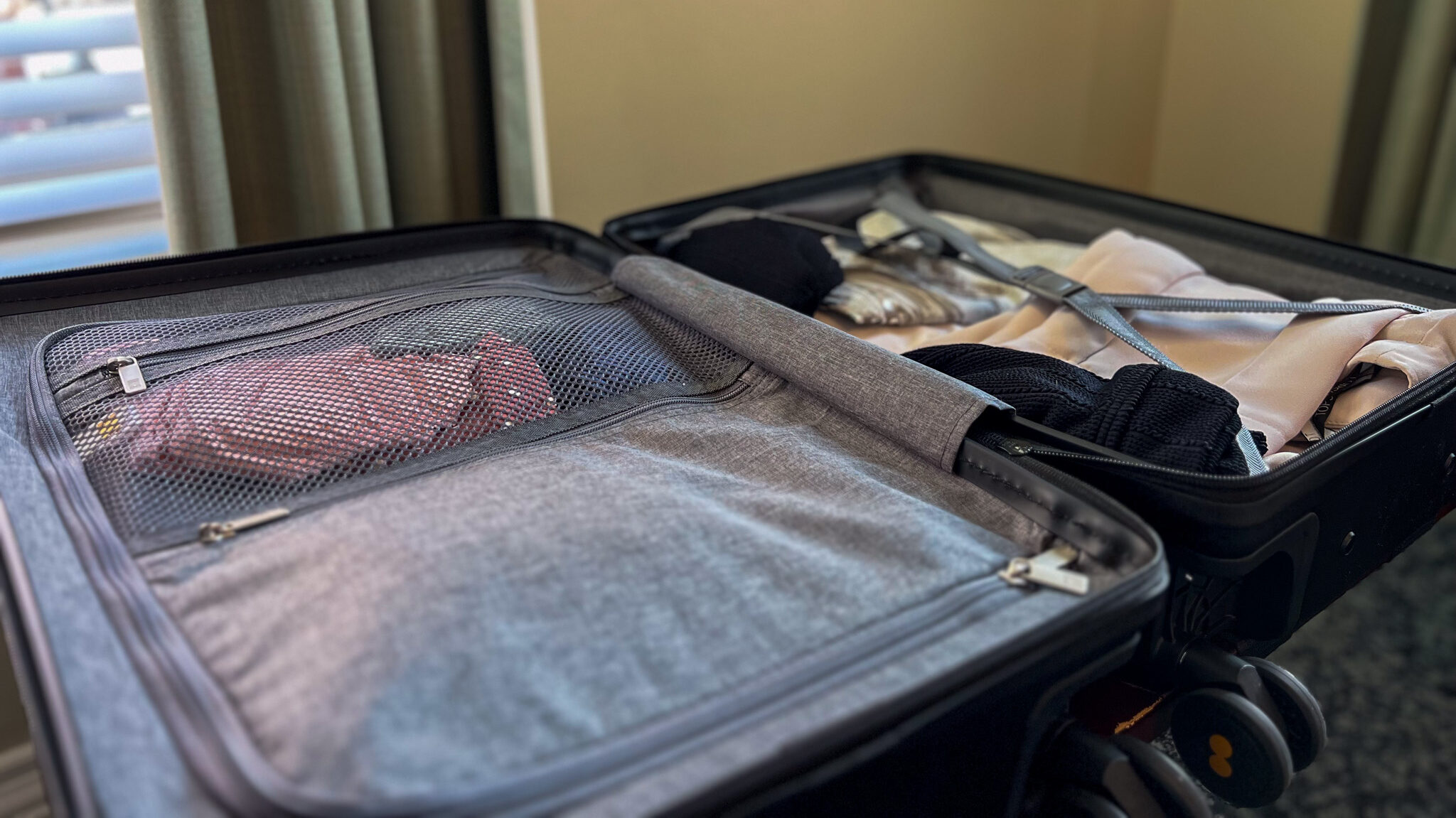 Carry-on suitcase opened with clothes inside.