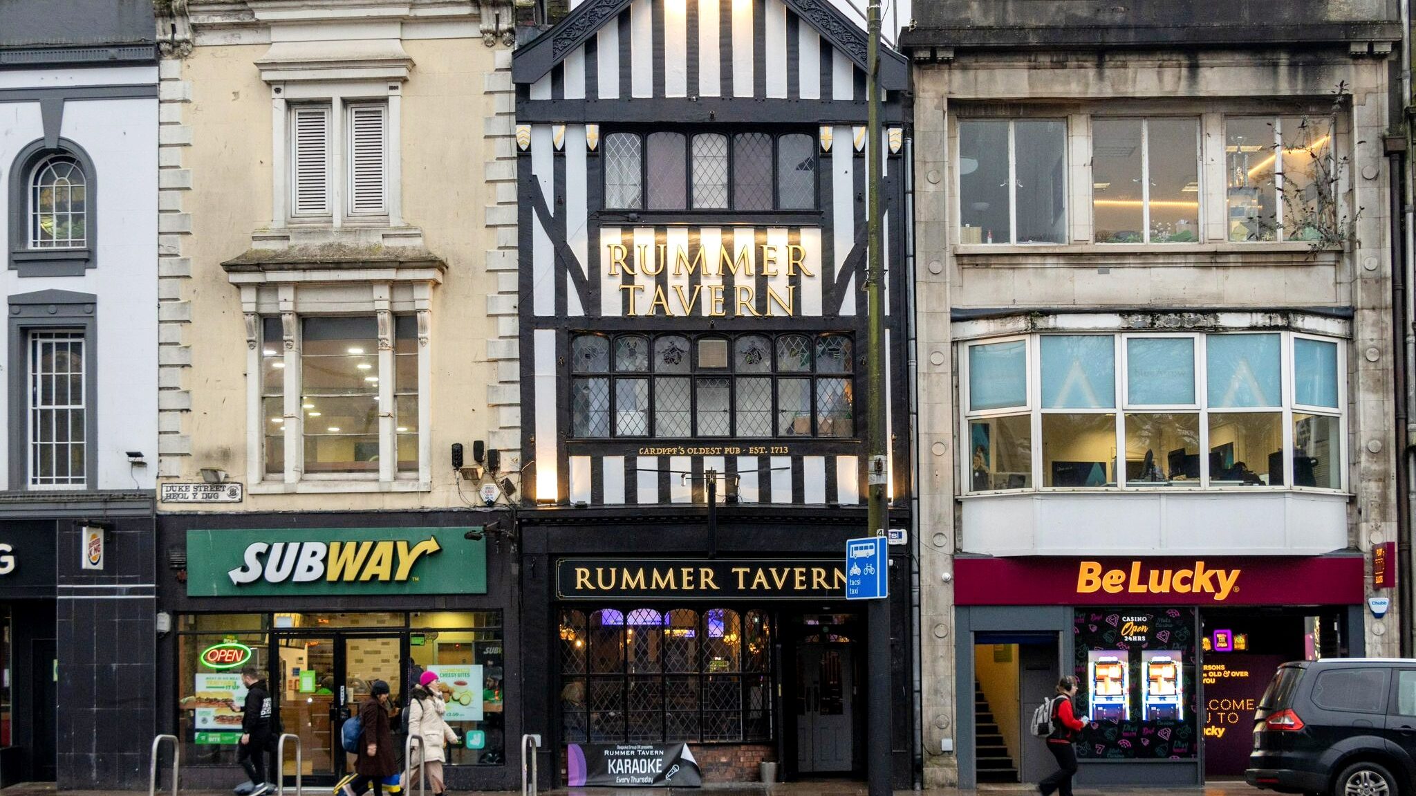 Black and white historic building between new shops.