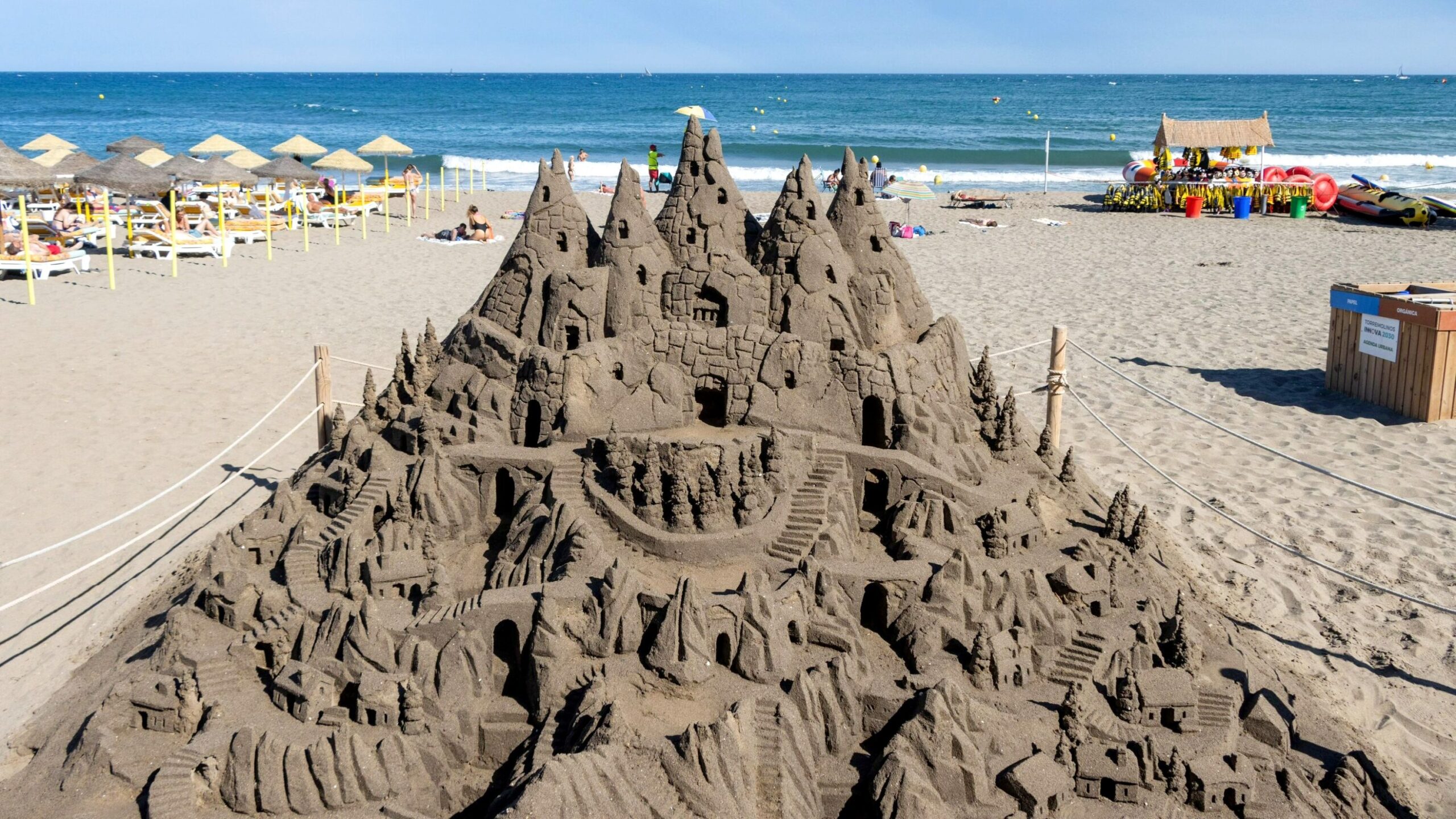 Large sand sculpture on beach.