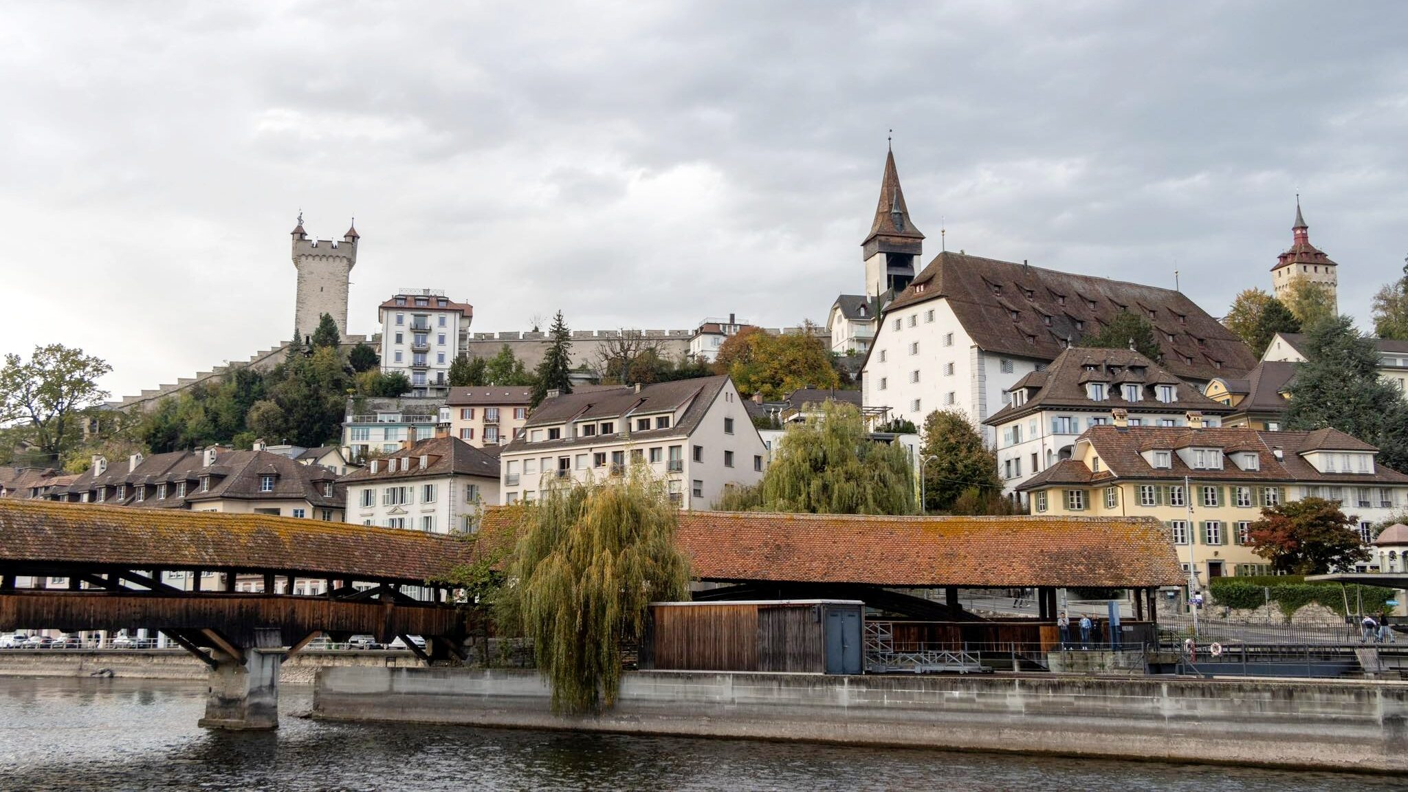 Small covered bridge with castle in the background.