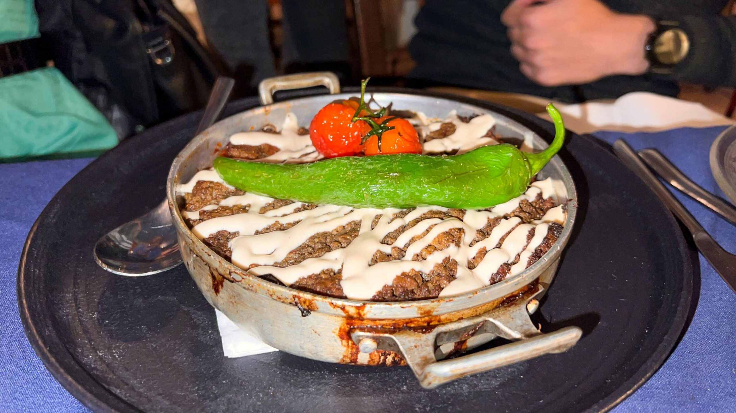 Dish of ground meat with green pepper on top.