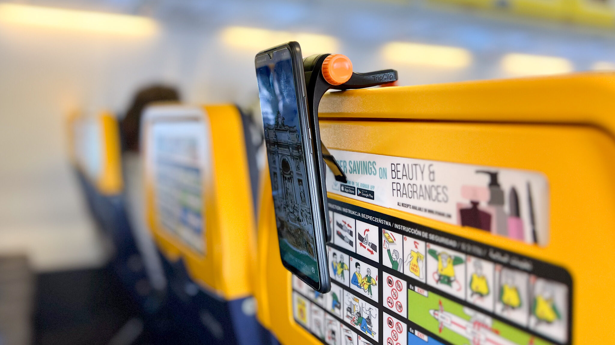 Clip on back of plane seat holding phone.