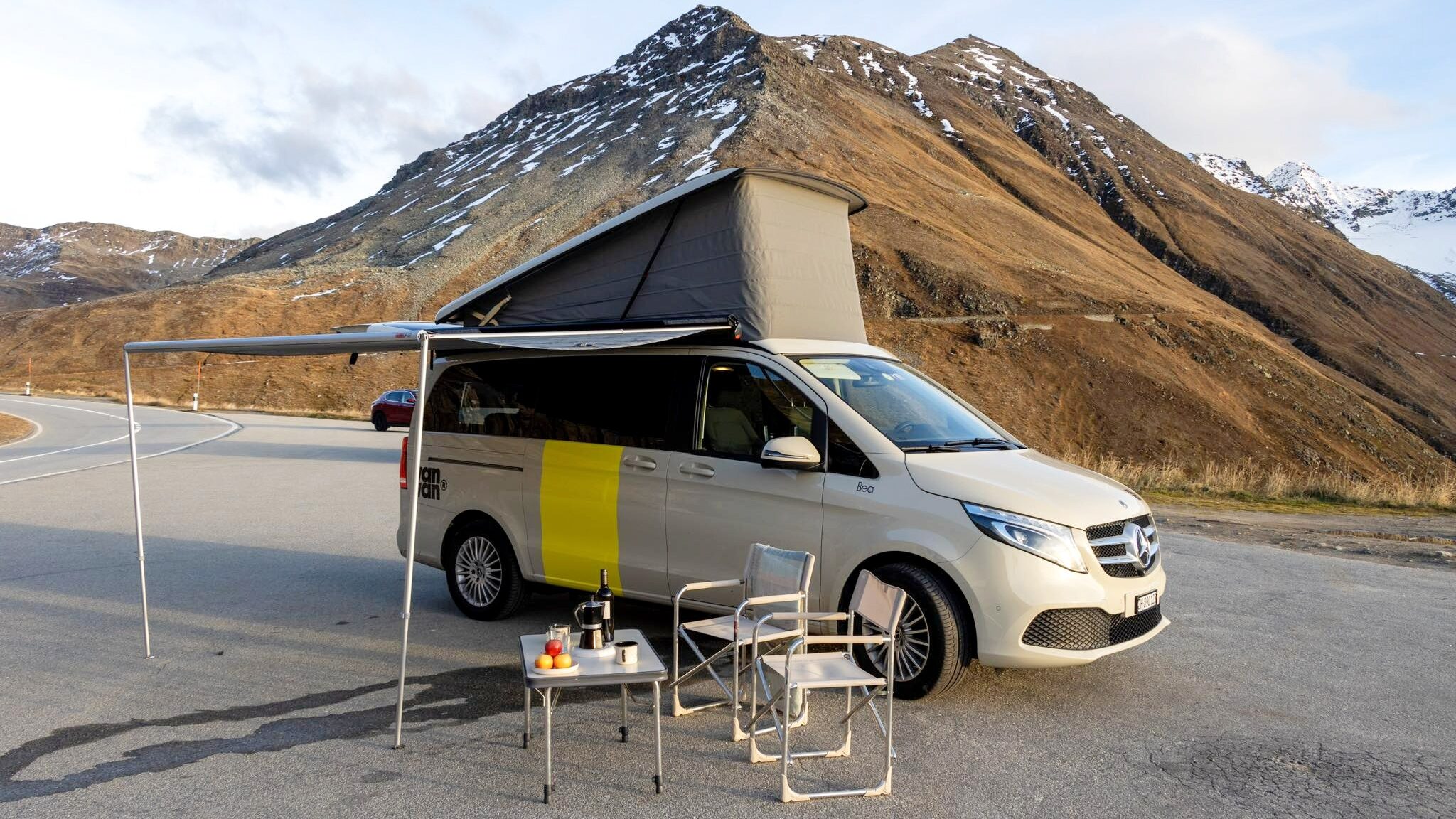 Camper van set up with table outside.