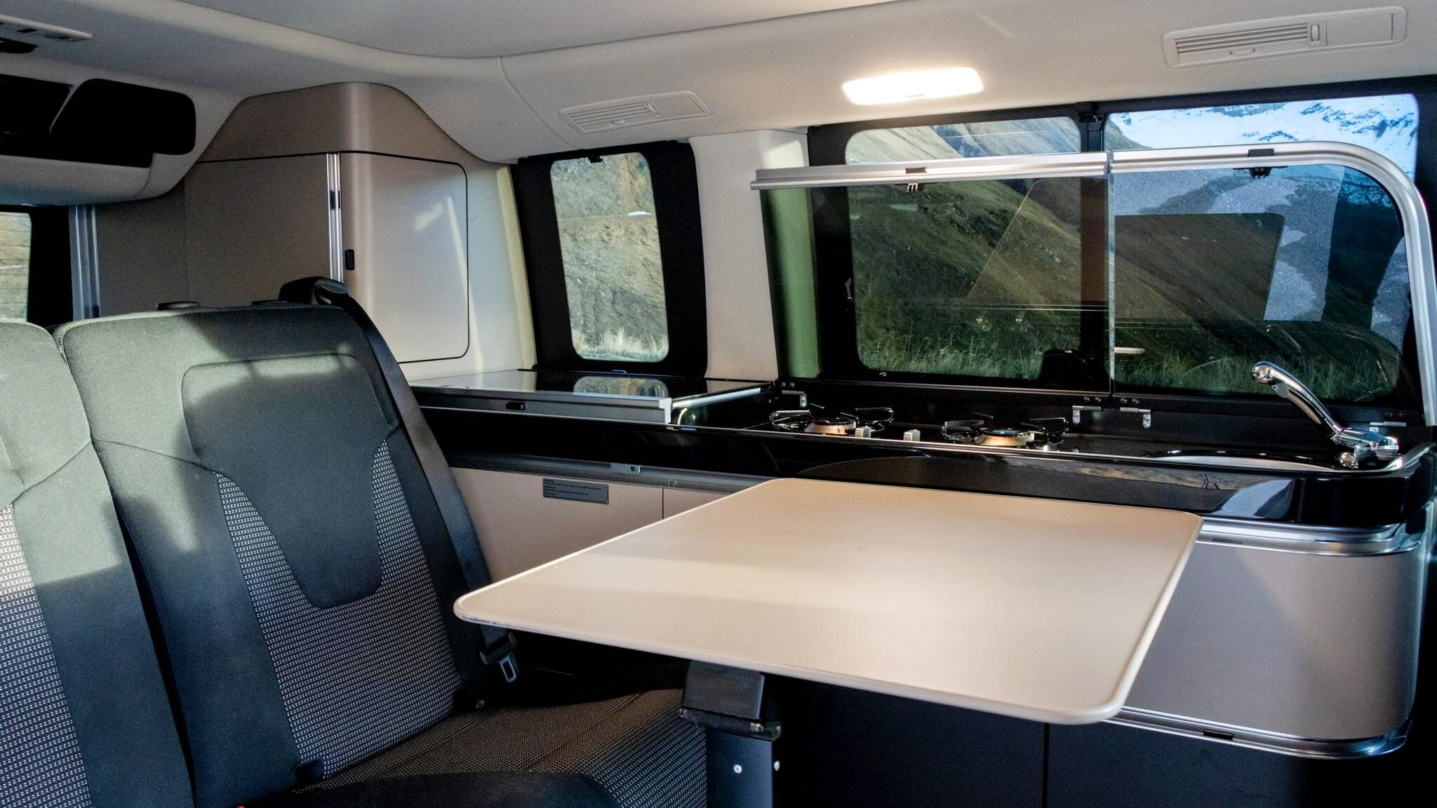 Back seats of camper van with interior table.