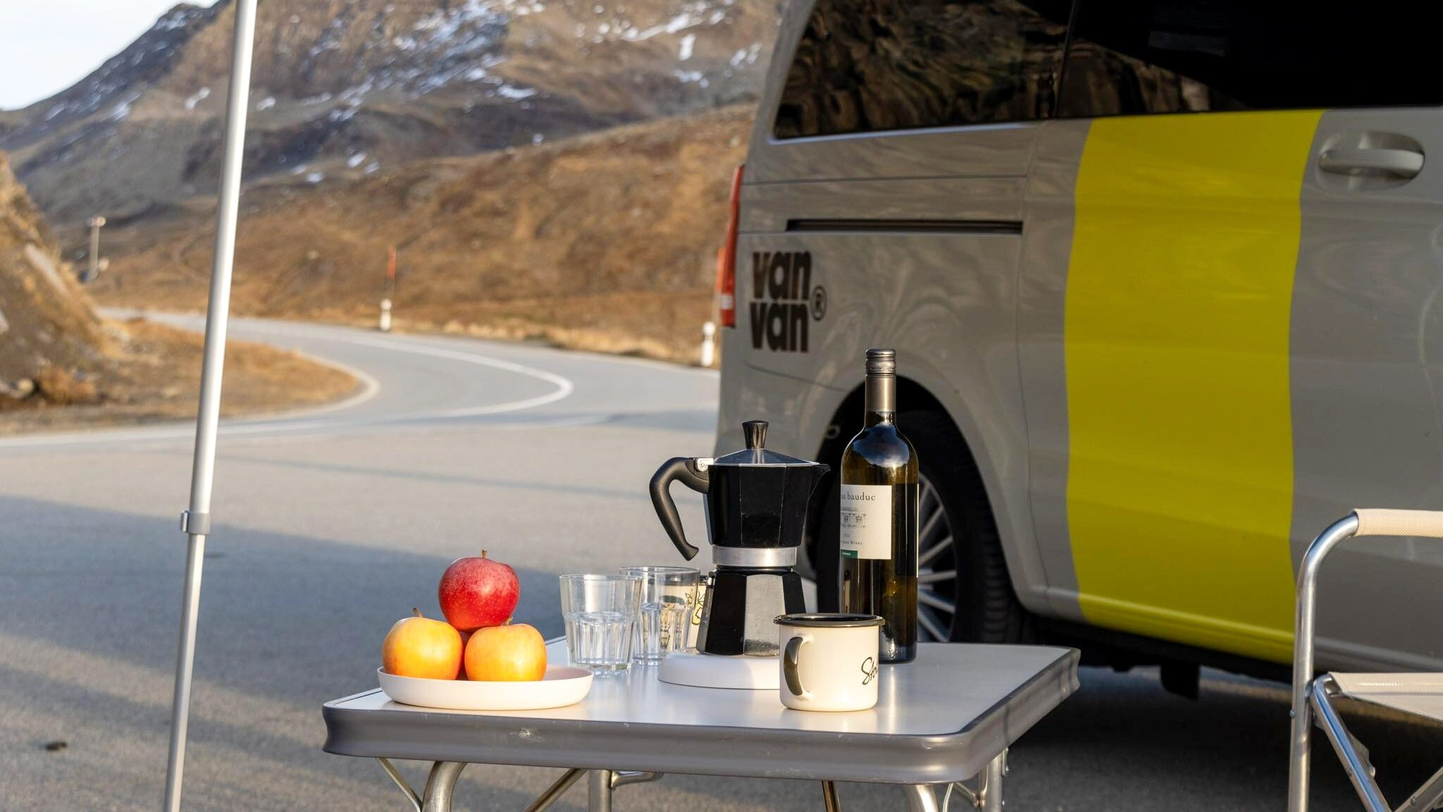 Table set up outside camper van with food.