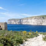 View of blue water and old watch tower.