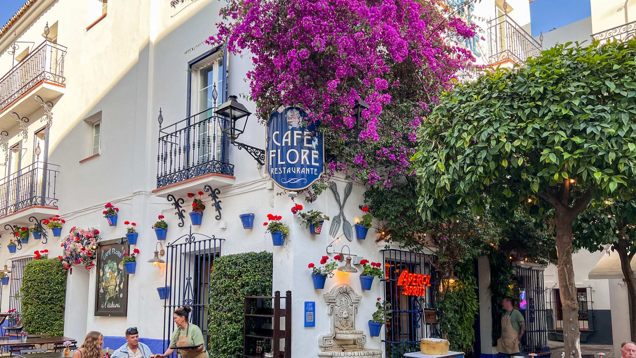 Restaurant in Marbella old town covered in purple flowers. 