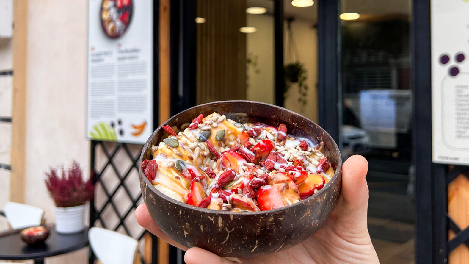 Acai bowl with fruit in front of shop.