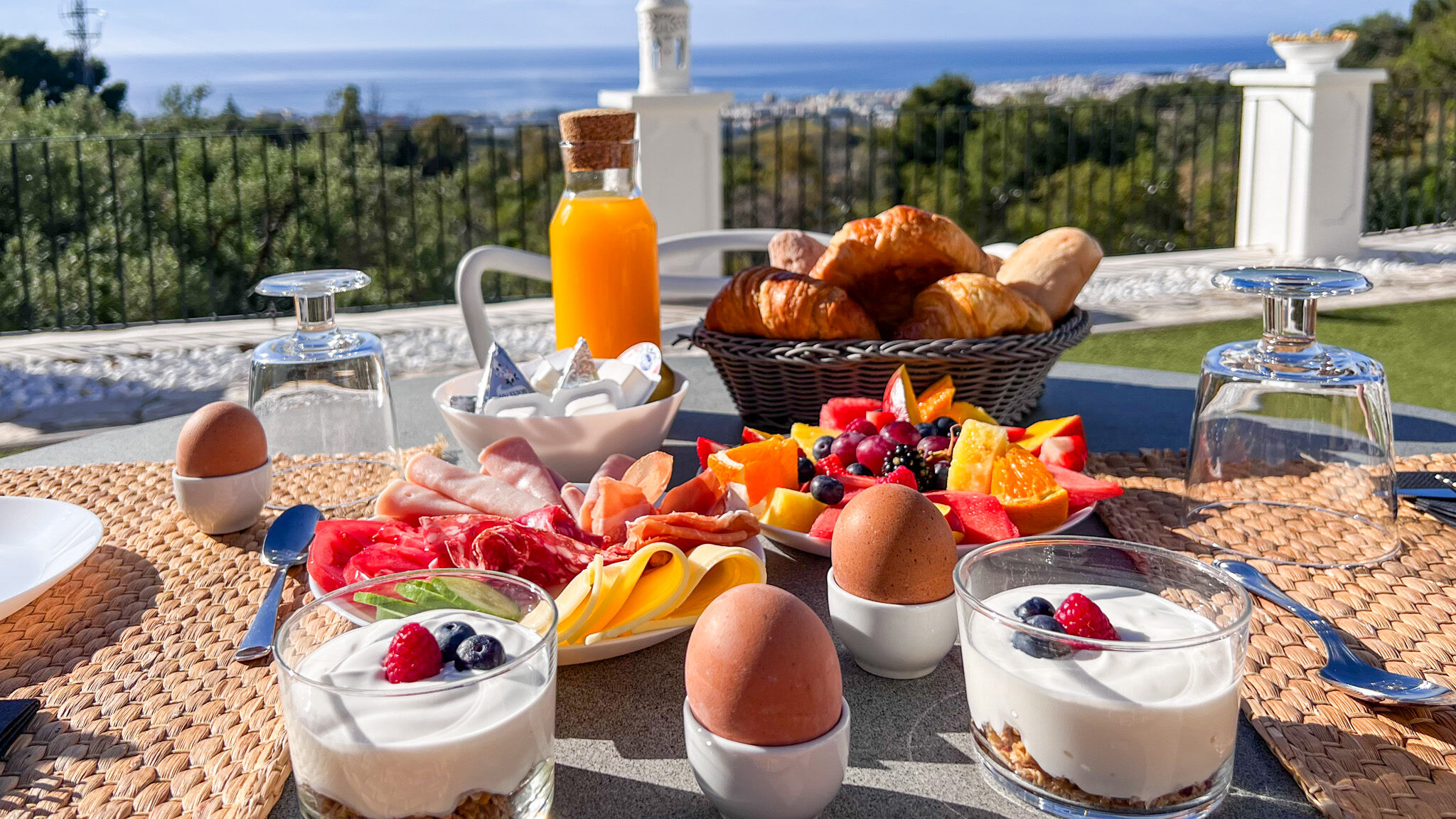 Continental breakfast setup on outdoor table.