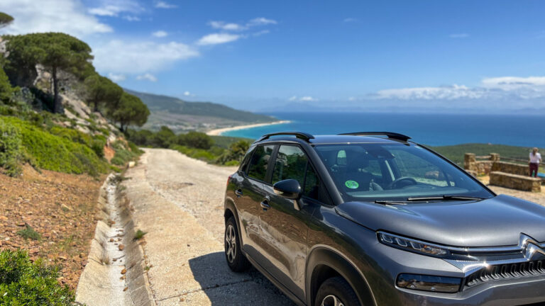 Car parked along road with sea view.