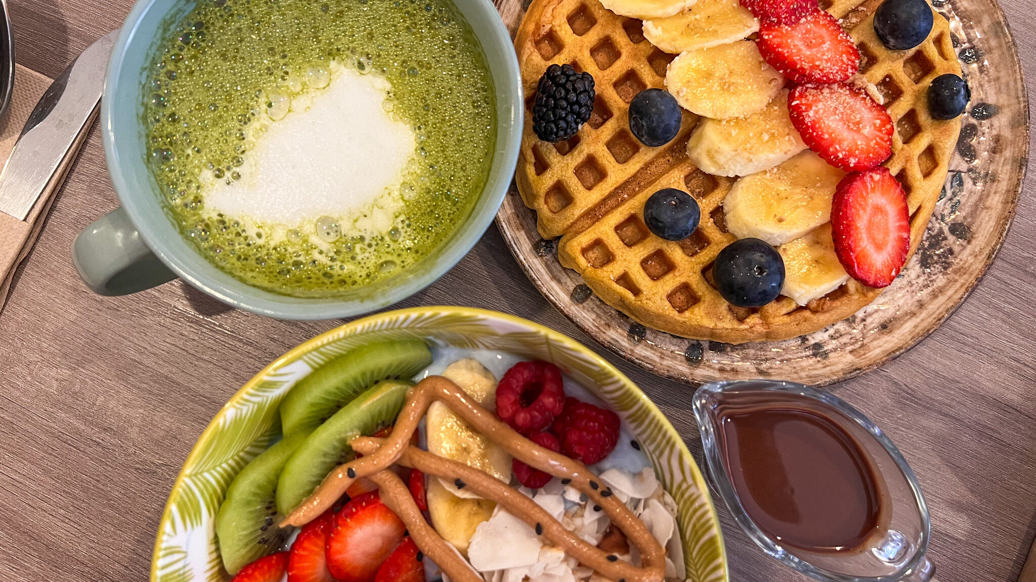 Acai bowl and breakfast waffle with matcha latte.