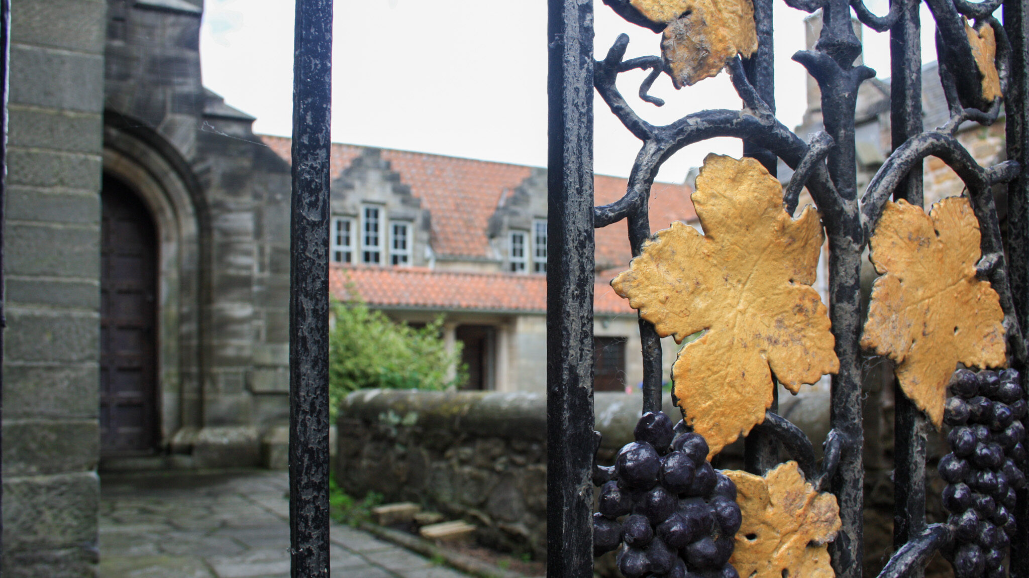 Cobbled street behind iron fence. 