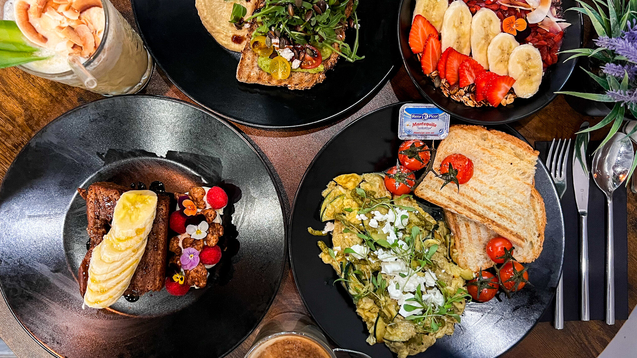 Black plates filled with healthy breakfast dishes.